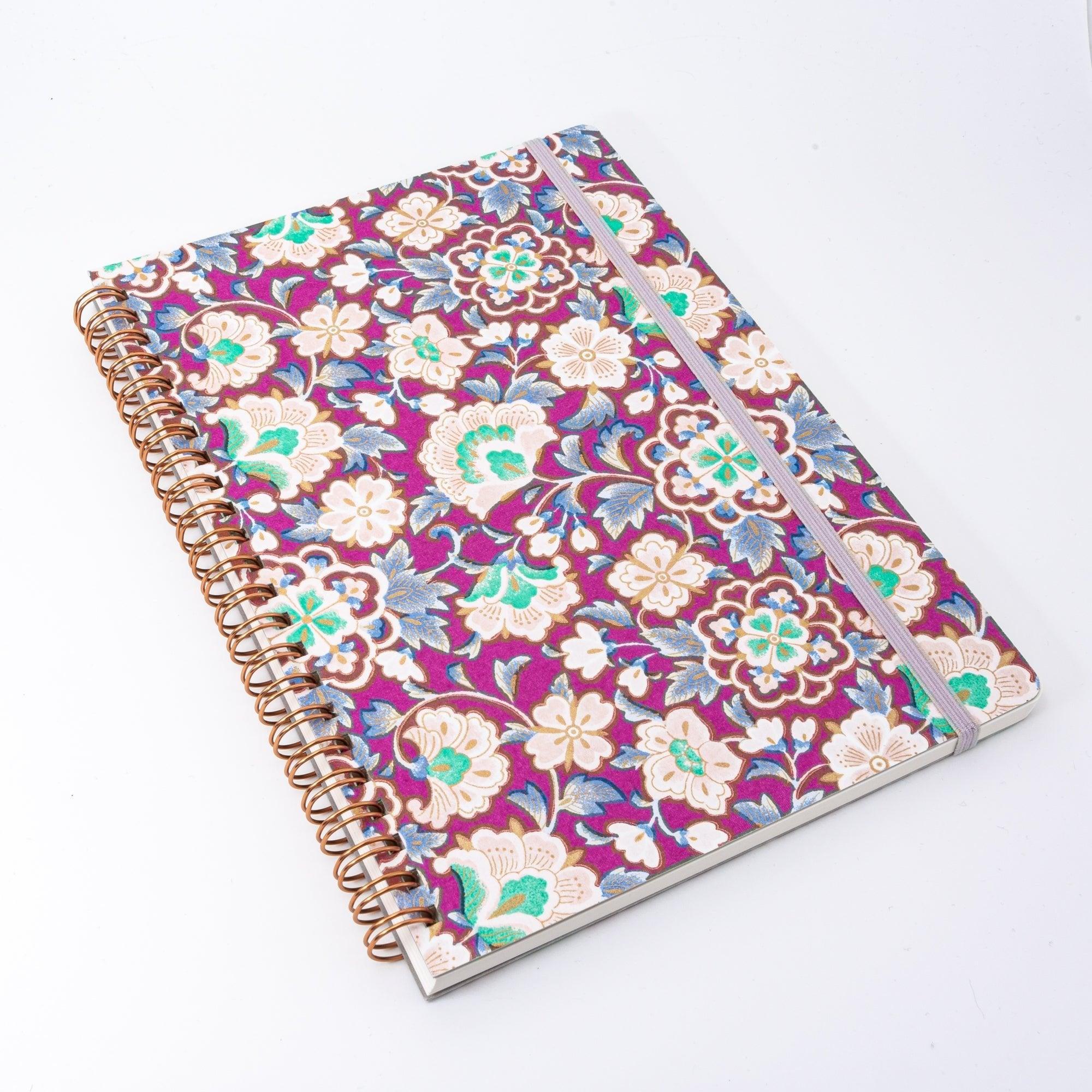 Magenta Garden Japanese ring notebook at a three-quarter angle showing washi floral cover and rose gold spiral binding