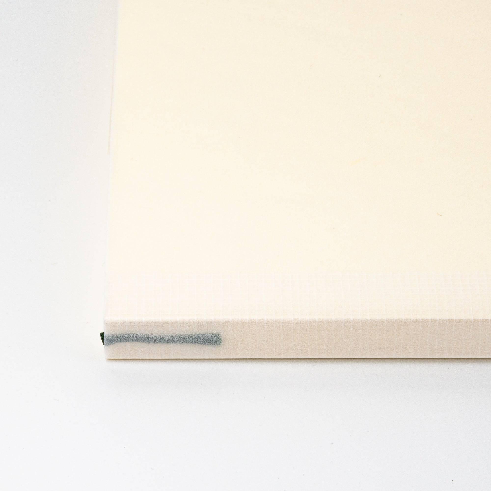 A close-up of the spine of a Japanese stationery MD Notebook, highlighting the textured binding and simple design for easy handling and durability.