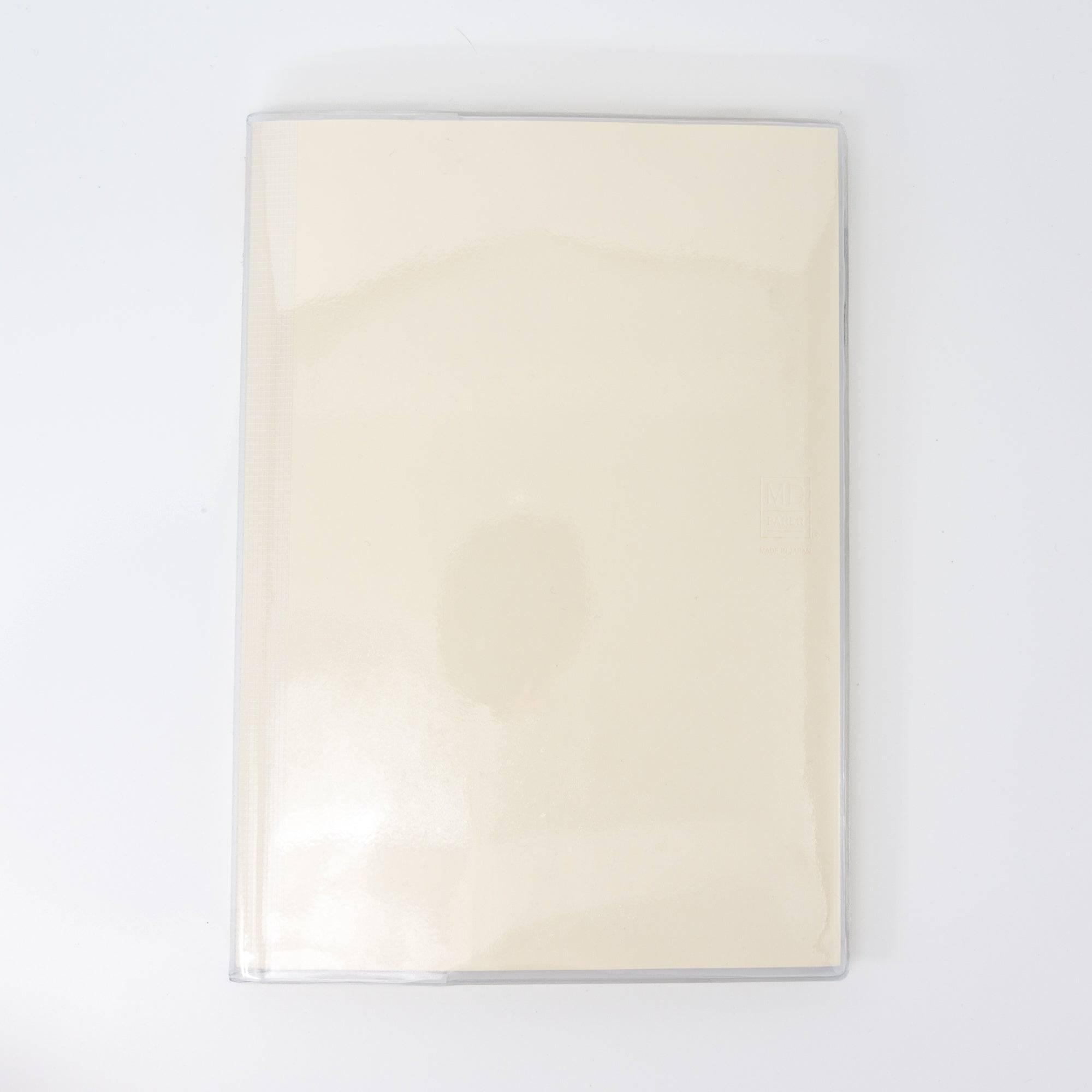 Back view of an MD notebook with a glossy transparent cover, showcasing its minimalistic aesthetic as part of Japanese stationery.