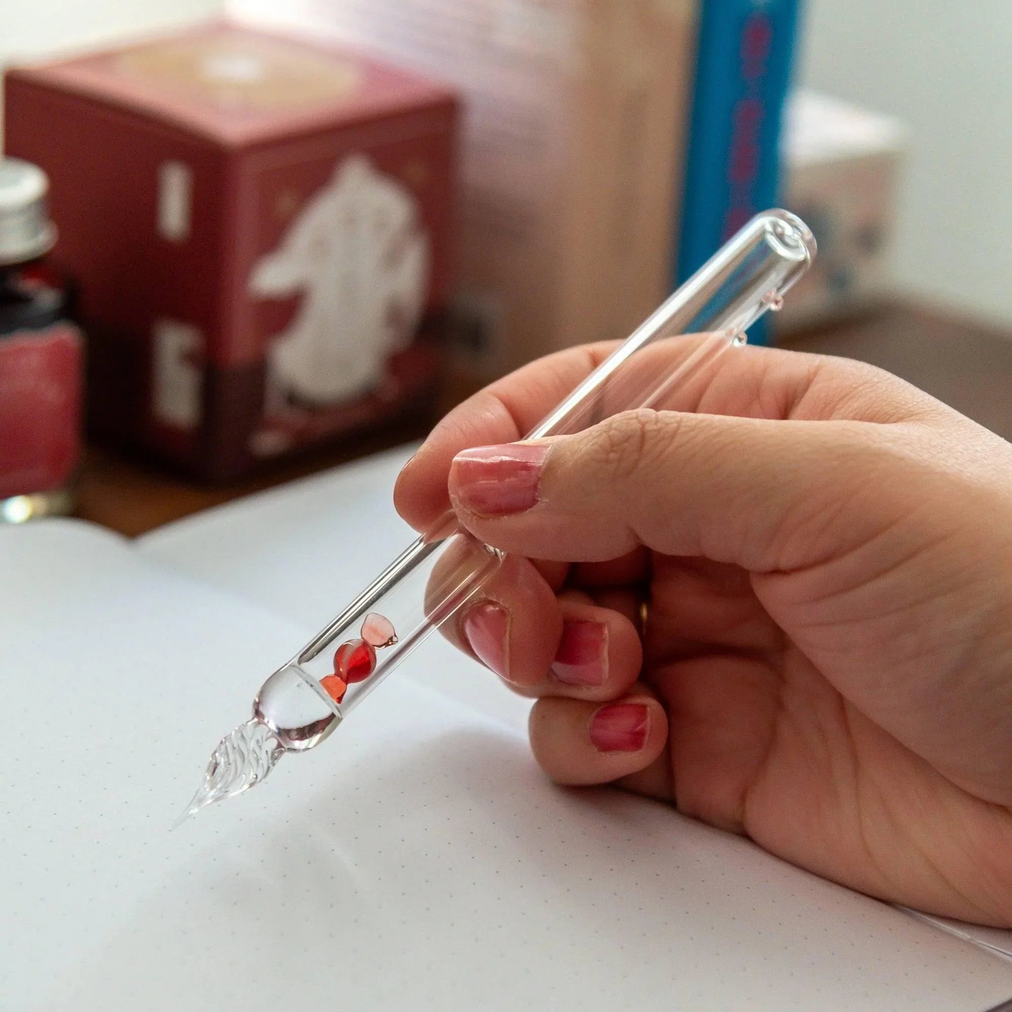 Japanese red glass dip pen with candy bubble design in profile showing twisted nib and glass inclusions with holder