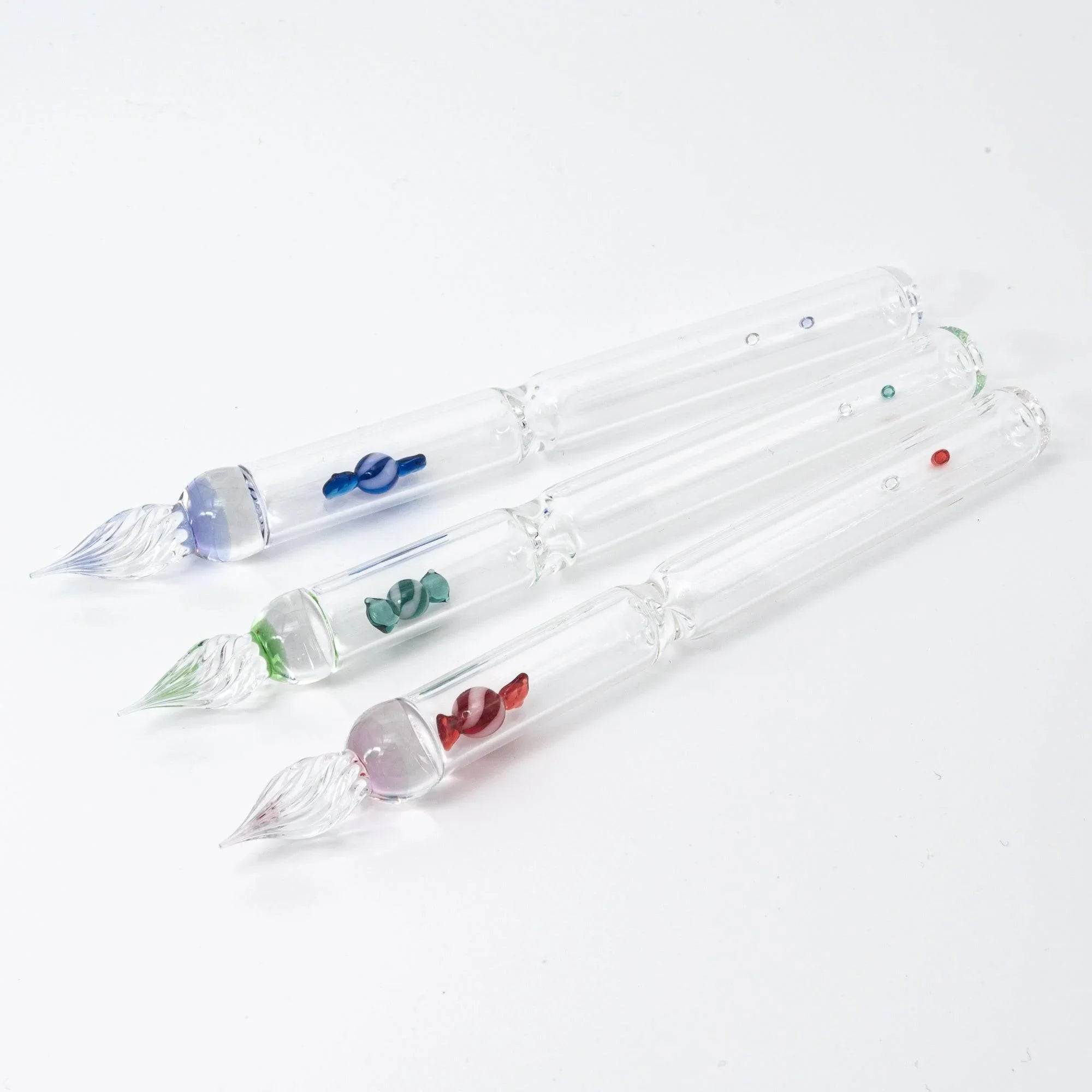 Red glass dip pen featuring bubble candy design in profile angle showing glass barrel and twisted nib with holder