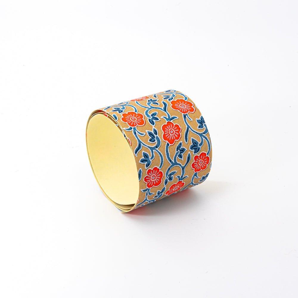 Red Flower yuzen washi tape standing upright showing yellow adhesive interior and coral-red floral arabesque on gold exterior
