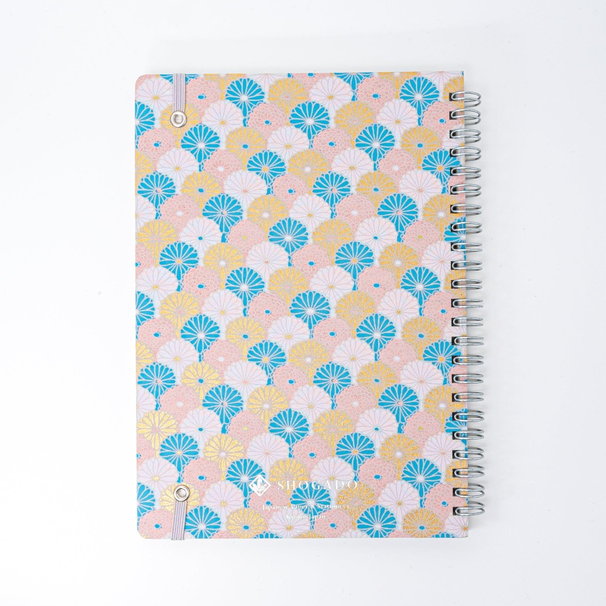 Spiral-bound Japanese notebook with a hand-dyed Yuzen washi cover, featuring fan-shaped patterns in blue, gold, and pink, showcasing Japanese stationery craftsmanship.