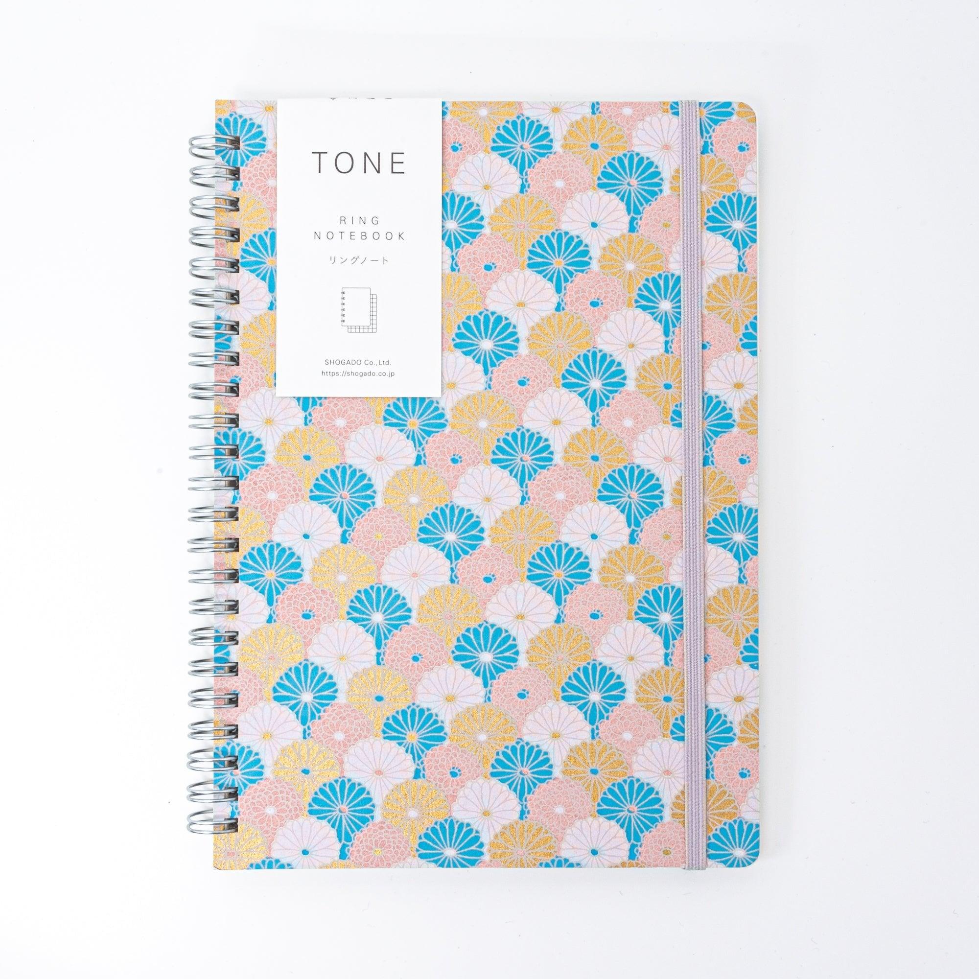 Spiral-bound Japanese notebook with a hand-dyed Yuzen washi cover, featuring fan-shaped patterns in blue, gold, and pink, showcasing Japanese stationery craftsmanship.