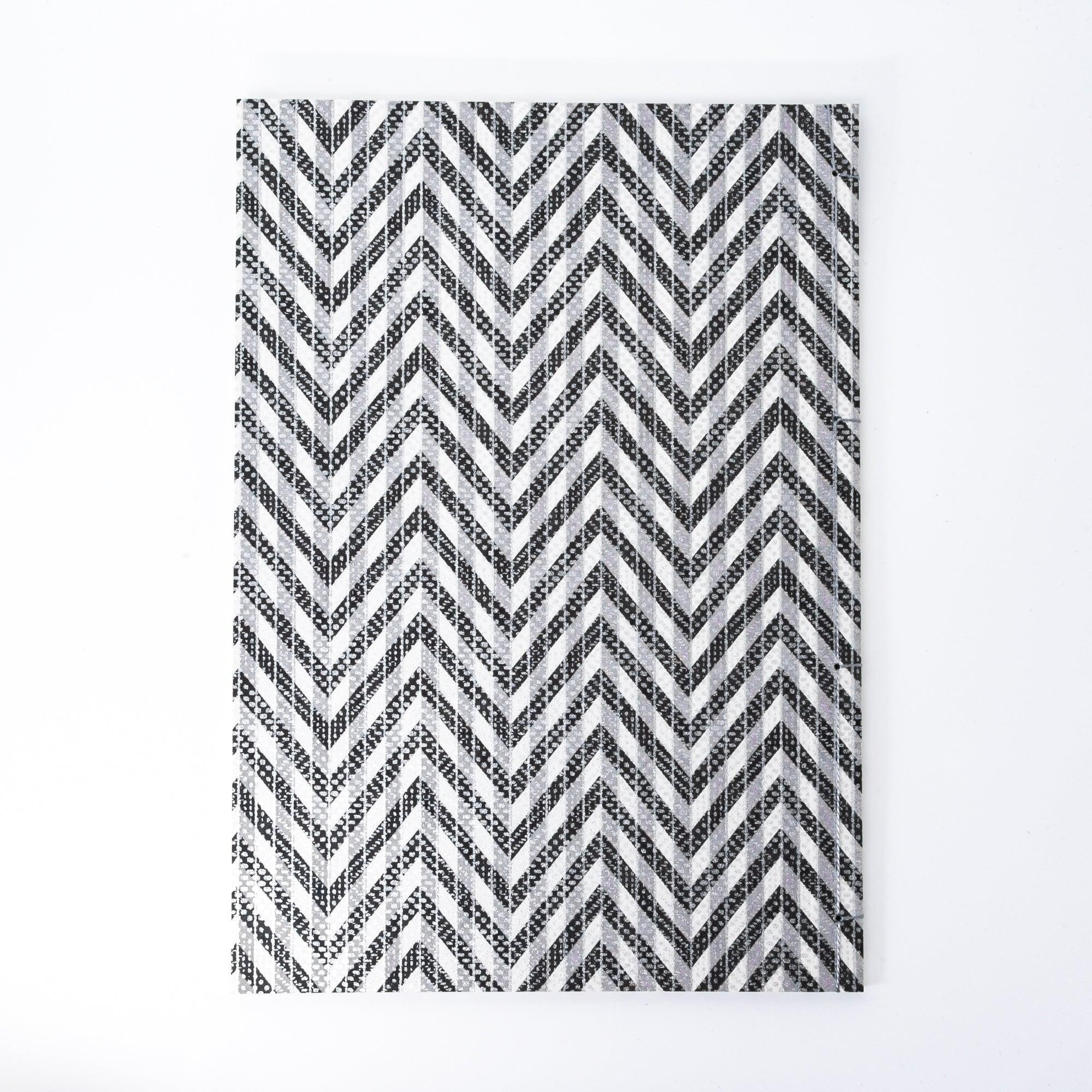 Notebook with a black and gray chevron-patterned cover, screenprinted by hand. Features bleed-proof paper for smooth writing. Made in Japan.
