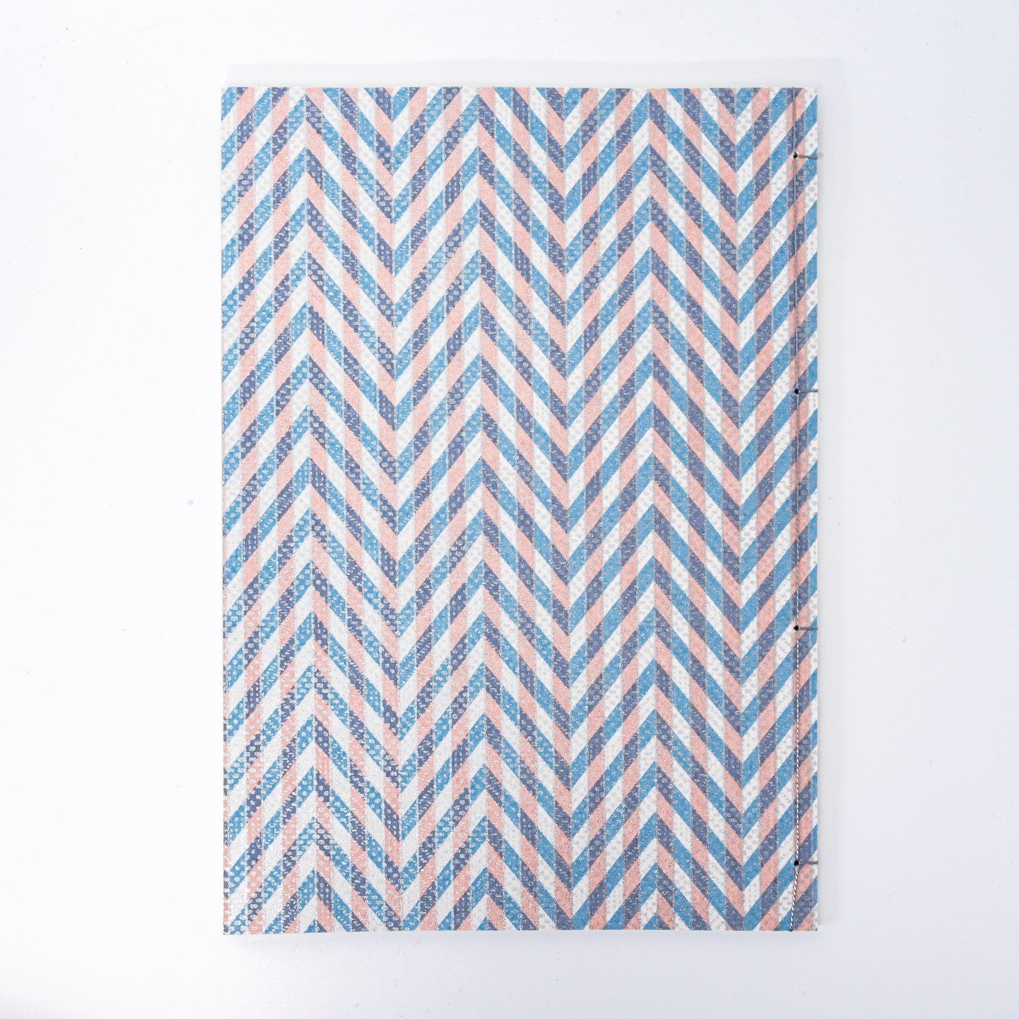 Notebook with a blue and pink chevron-patterned cover, screenprinted by hand. Features bleed-proof paper for smooth writing. Made in Japan.