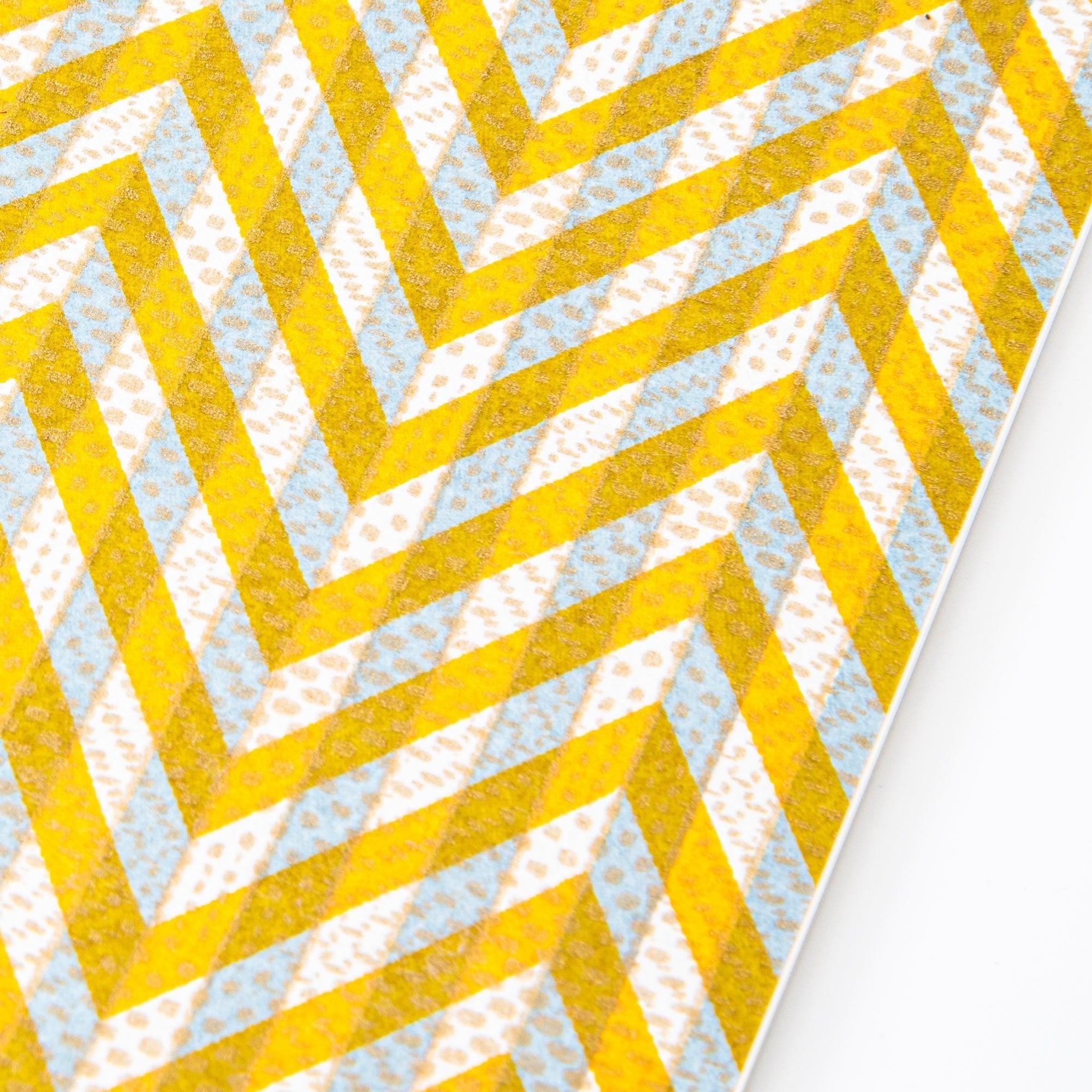 Notebook with a yellow and gray chevron-patterned cover, screenprinted by hand. Features bleed-proof paper for smooth writing. Made in Japan.