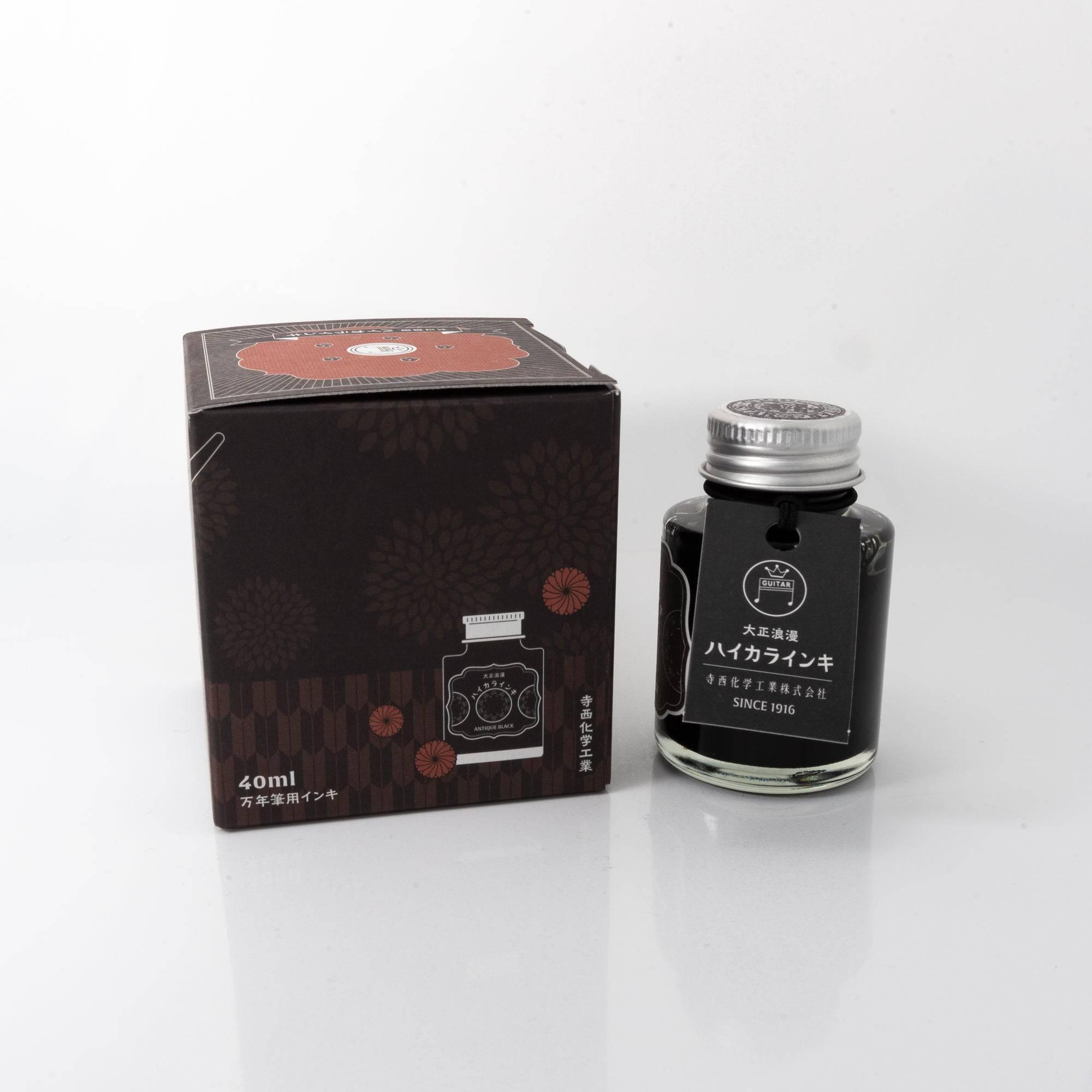 Open Taisho Romance Antique Black ink bottle with bold black liquid, placed beside a fountain pen, blending functionality with nostalgia.