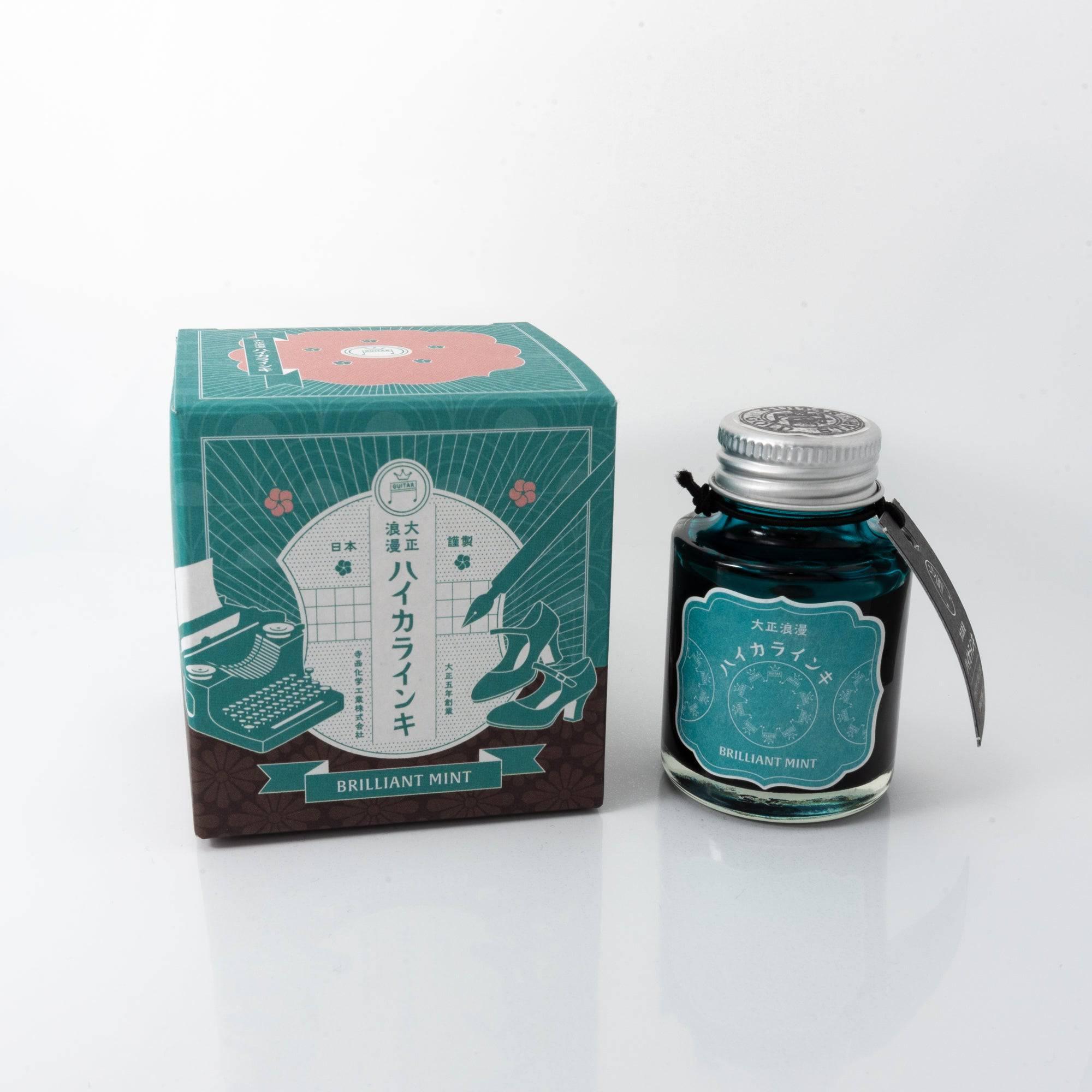 Taisho Romance Brilliant Mint fountain pen ink bottle with a vibrant mint hue, placed on a wooden desk under soft natural light.