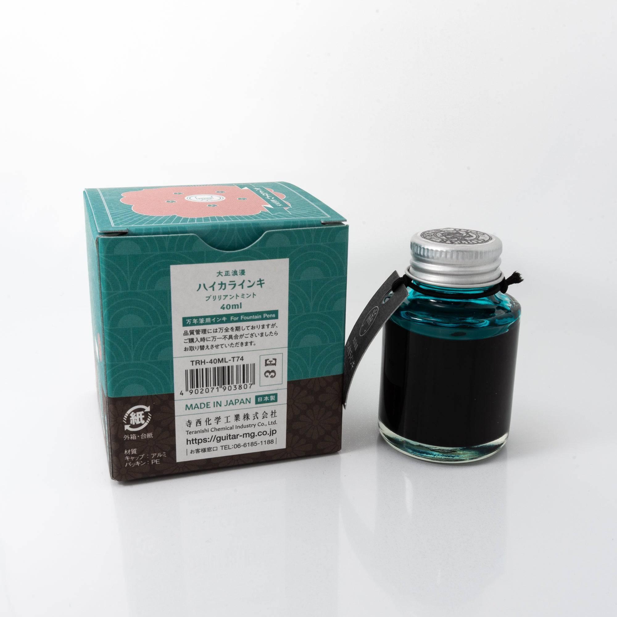 Top view of the Taisho Romance Brilliant Mint ink bottle, highlighting its fresh mint ink, surrounded by natural wooden tones.