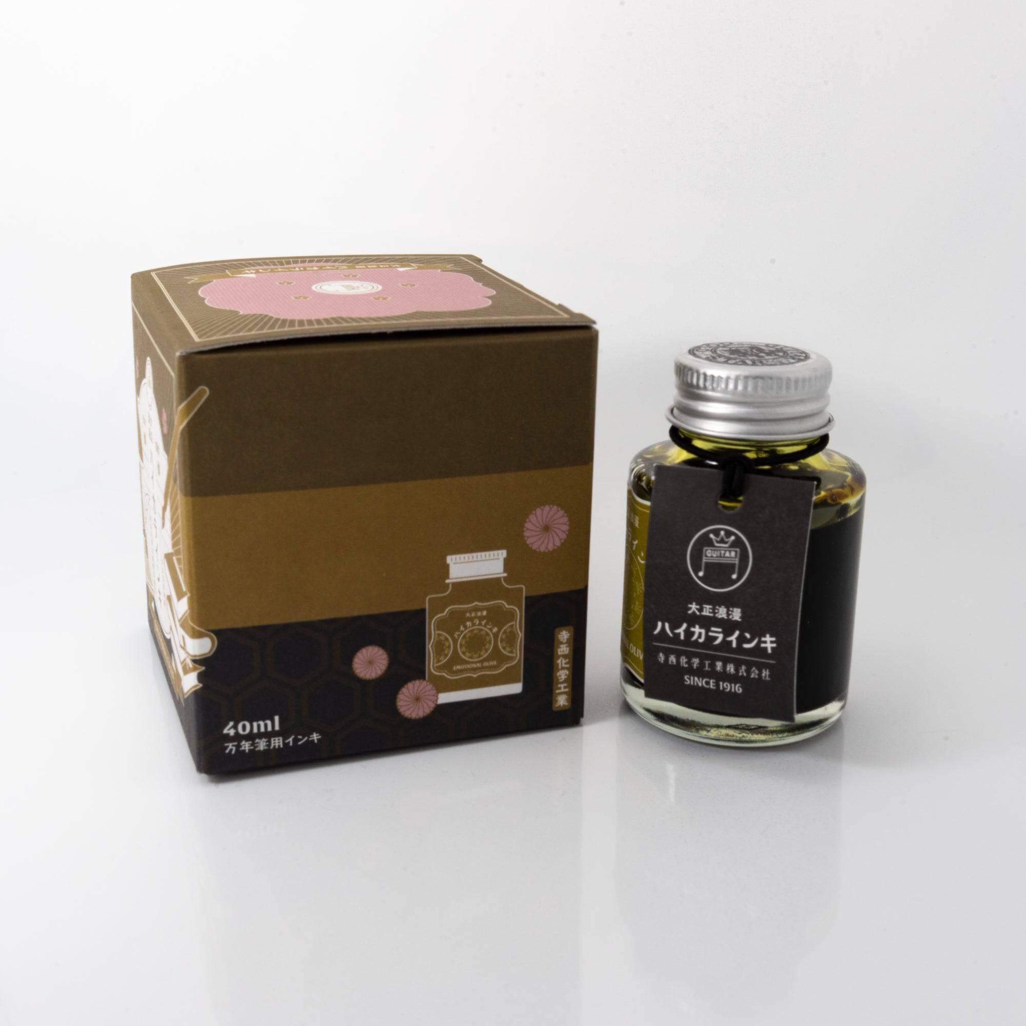 Open Taisho Romance Emotional Olive ink bottle with soft olive liquid, placed beside a fountain pen, blending style and functionality.