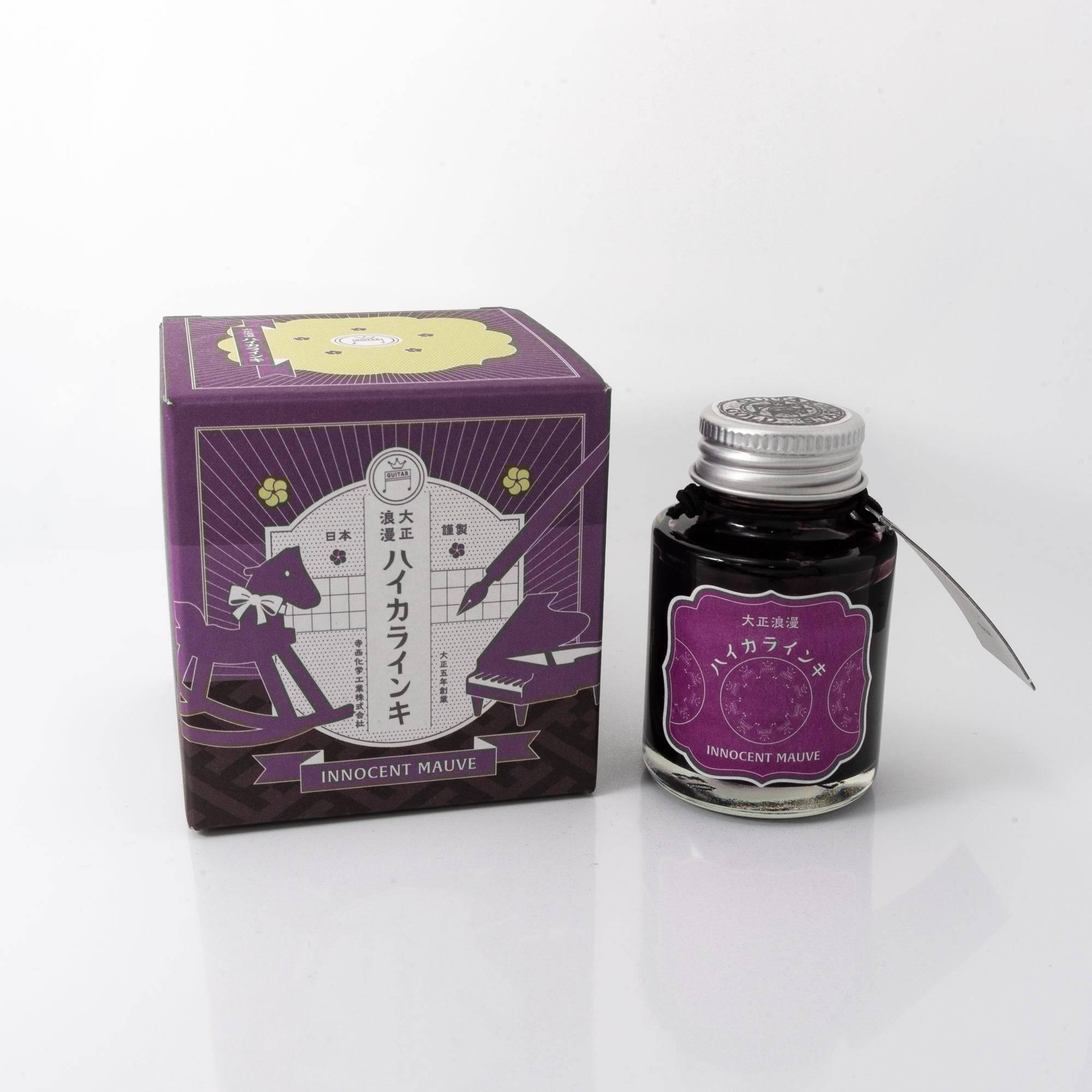 Taisho Romance Innocent Mauve fountain pen ink bottle with a soft mauve hue, placed on a wooden desk under gentle natural light.