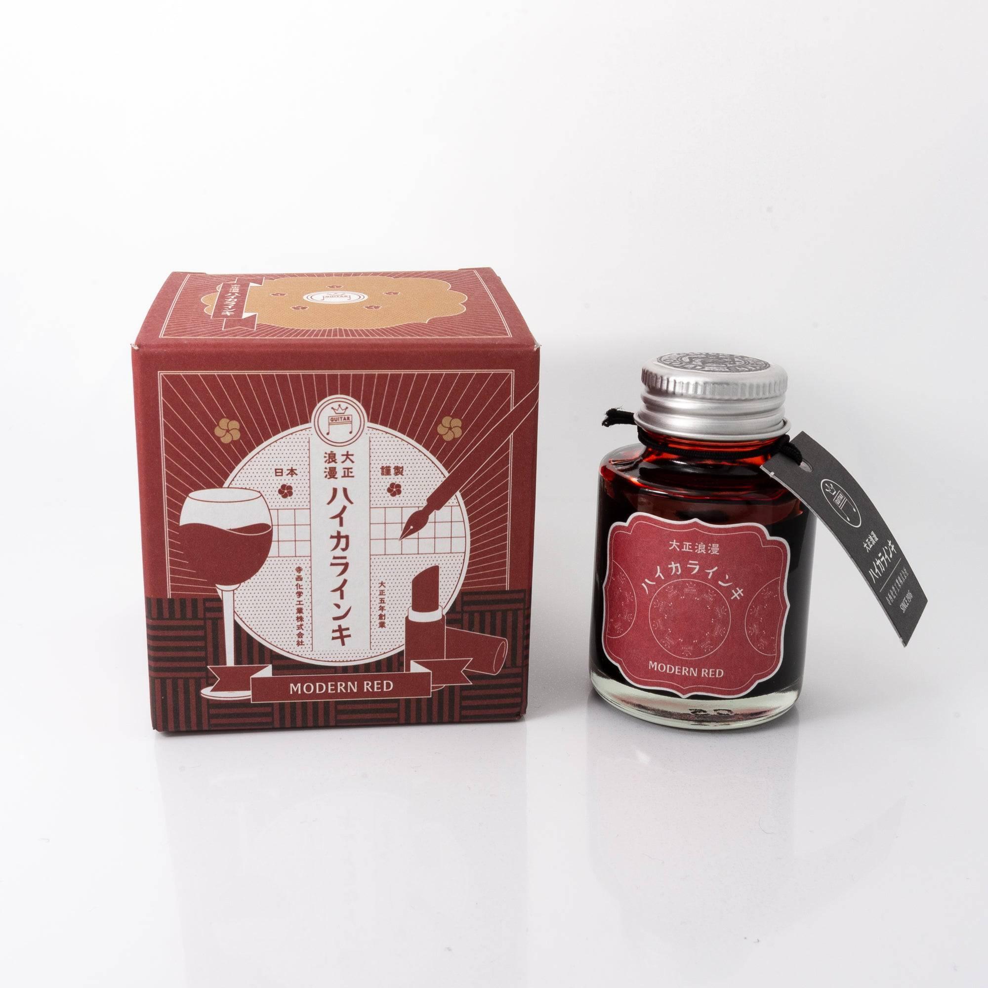 Taisho Romance Modern Red fountain pen ink bottle with a bold crimson hue, placed on a wooden desk under soft natural light.