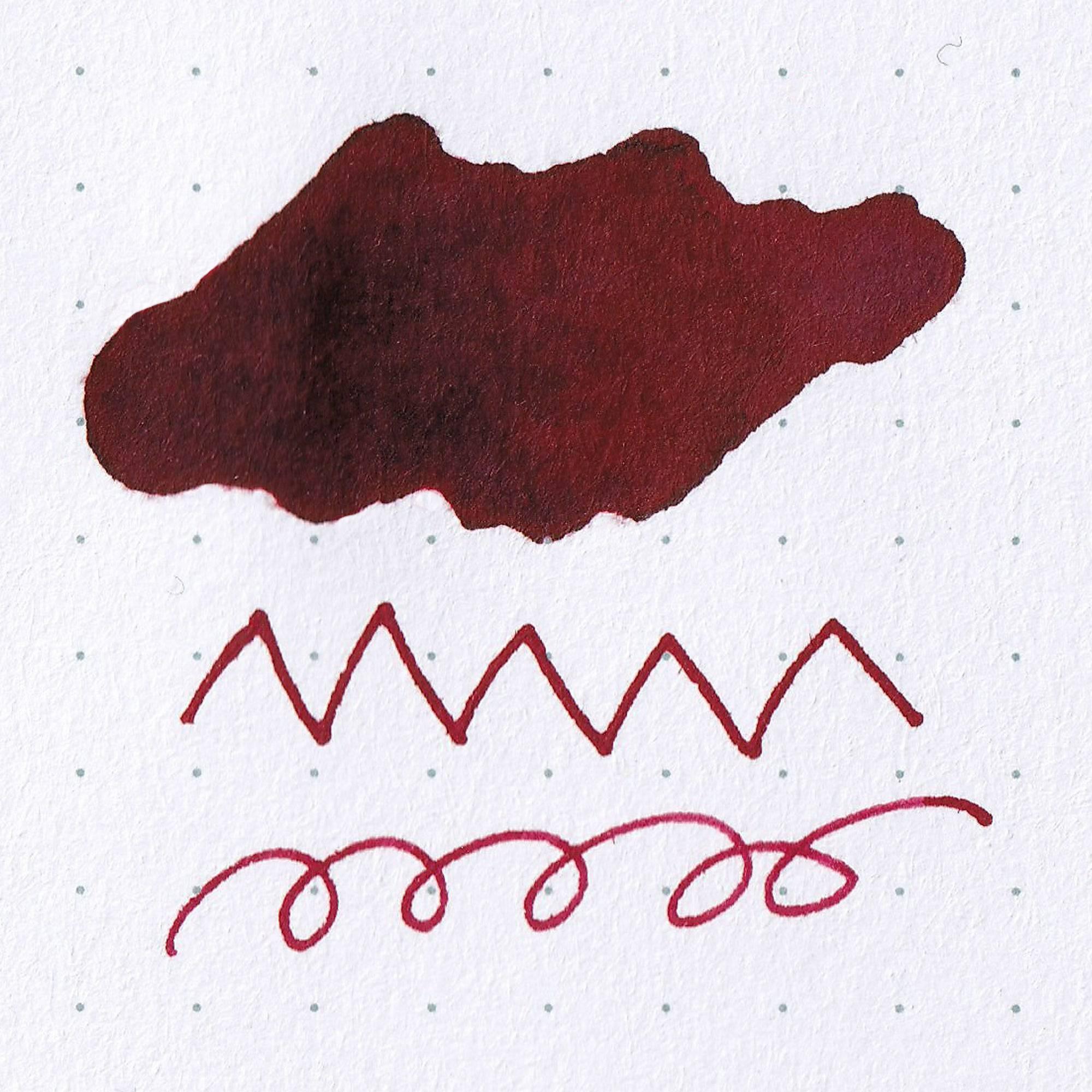 Close-up of Taisho Romance Modern Red ink bottle, showcasing its deep red ink and vintage-inspired label on a wooden surface.