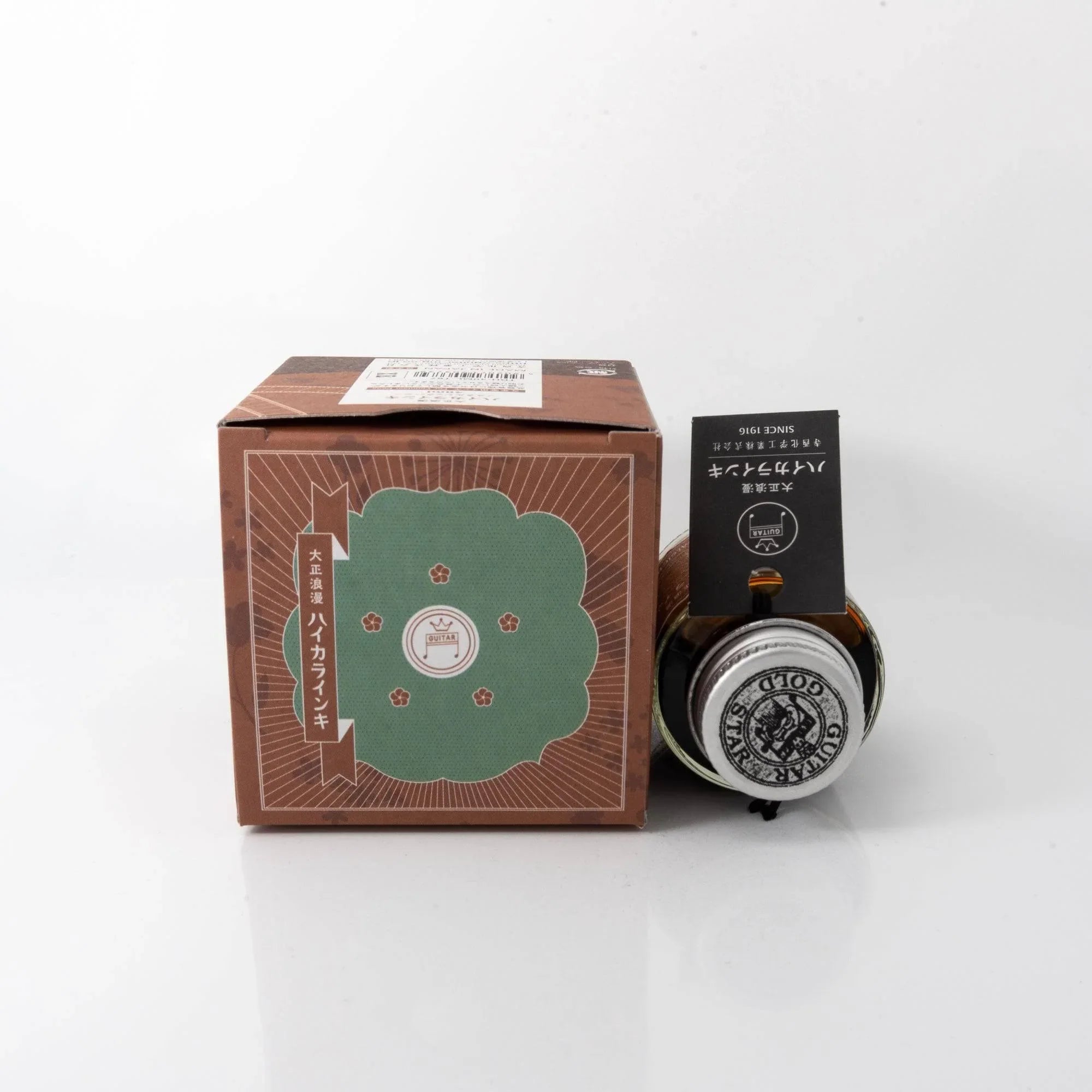 Close-up detail of Taisho Romance Nostalgic Honey fountain pen ink glass bottle showing metal cap label