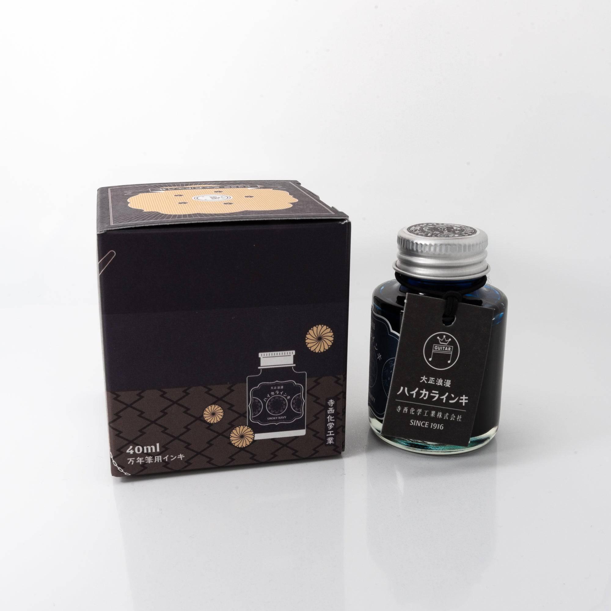 Open Taisho Romance Smoky Navy ink bottle with bold navy liquid, placed beside a fountain pen, blending style and functionality.