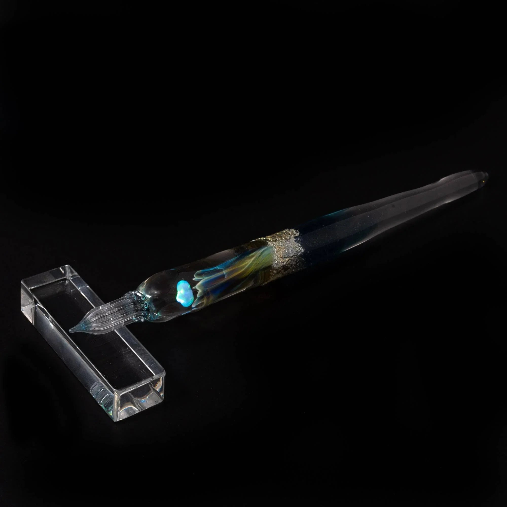 Side profile of light blue moon goddess glass dip pen with tapered barrel and hand-made twisted nib partially unrolled