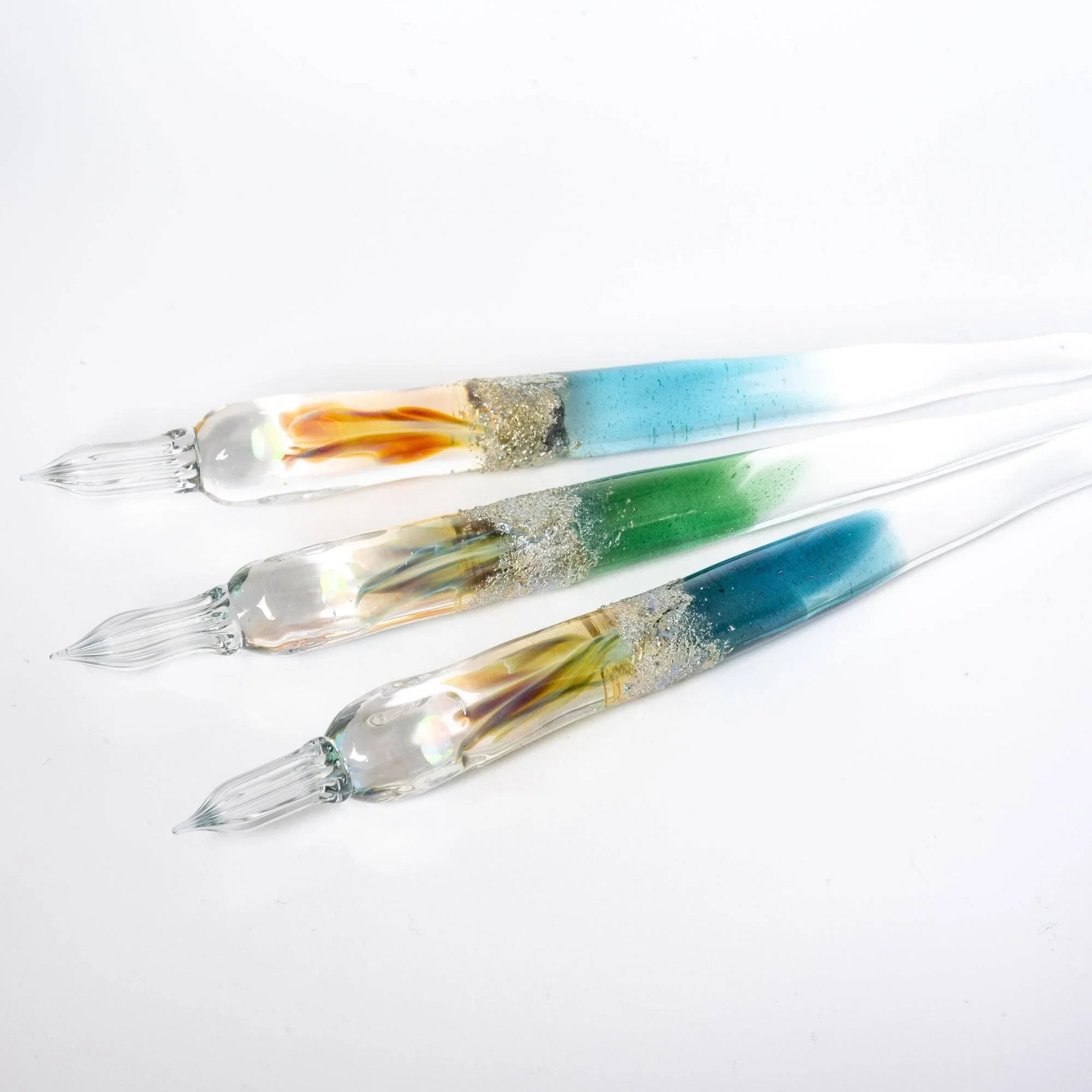 hand-made light blue glass dip pen displayed in profile with transparent barrel and nib detail shine