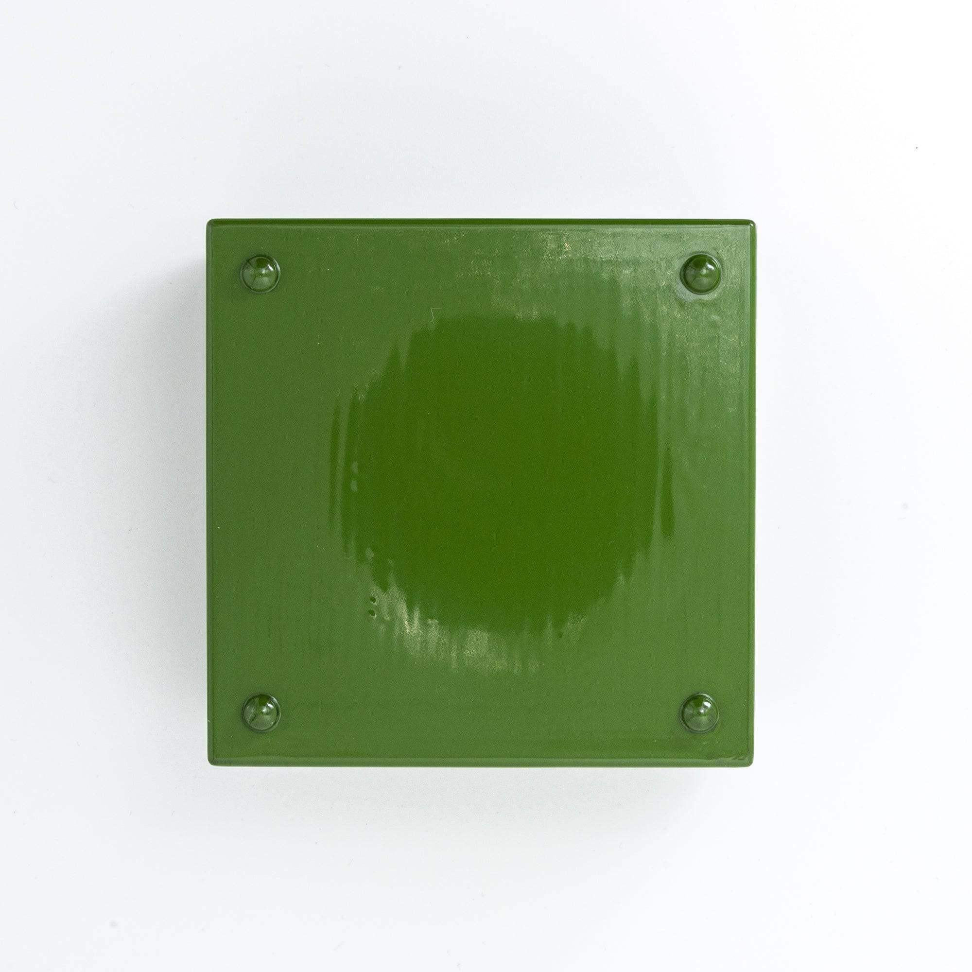 Bottom view of a green Japanese lacquer stationery box, featuring a glossy surface with four small support pads, displayed against a clean white background.