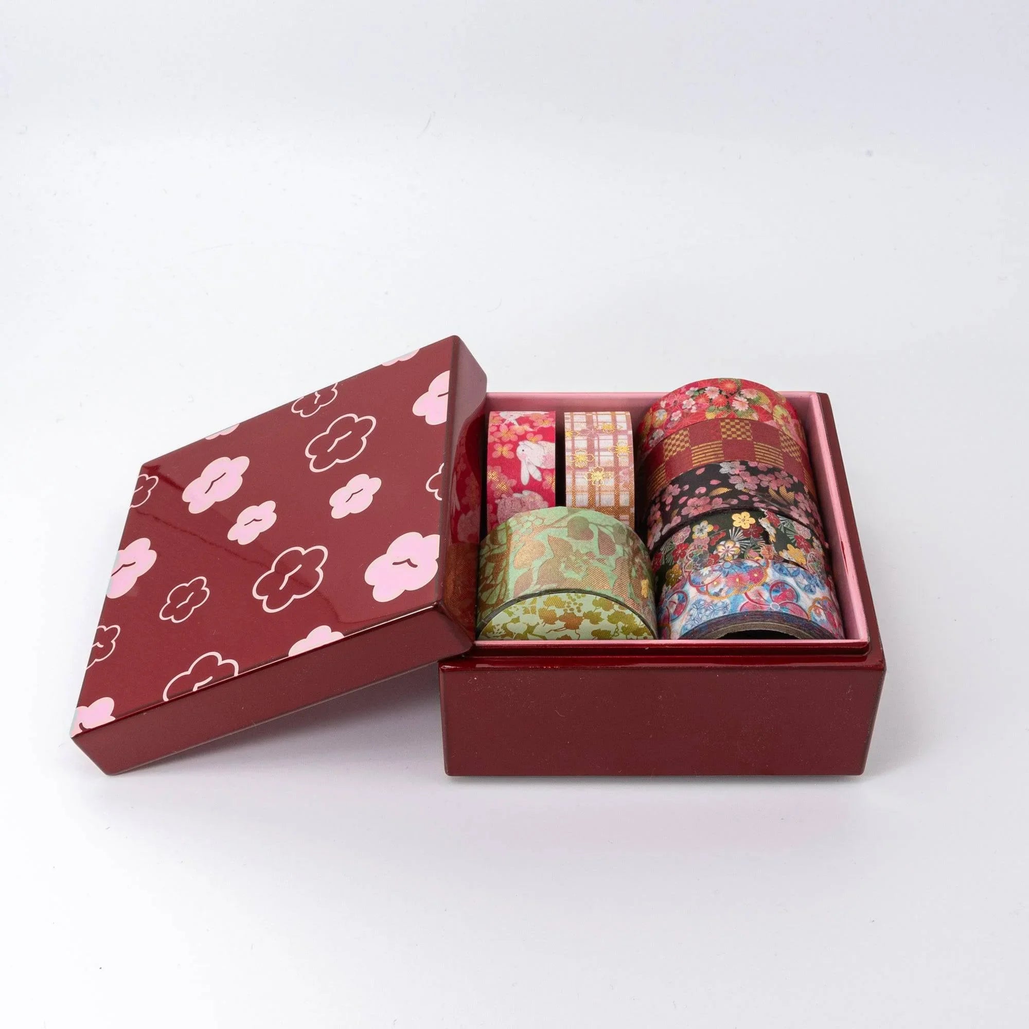 Urushi kohako plum trinket box closed detail view showing burgundy-red lacquer with gold and pink plum flower design