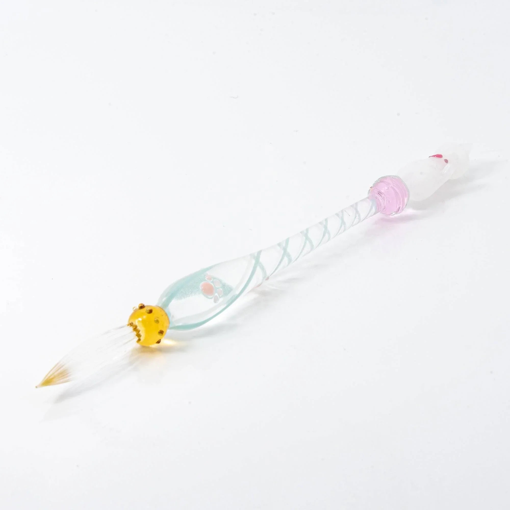 White Nyanko cat figure detail on clear glass dip pen with transparent spiral-etched handle composition