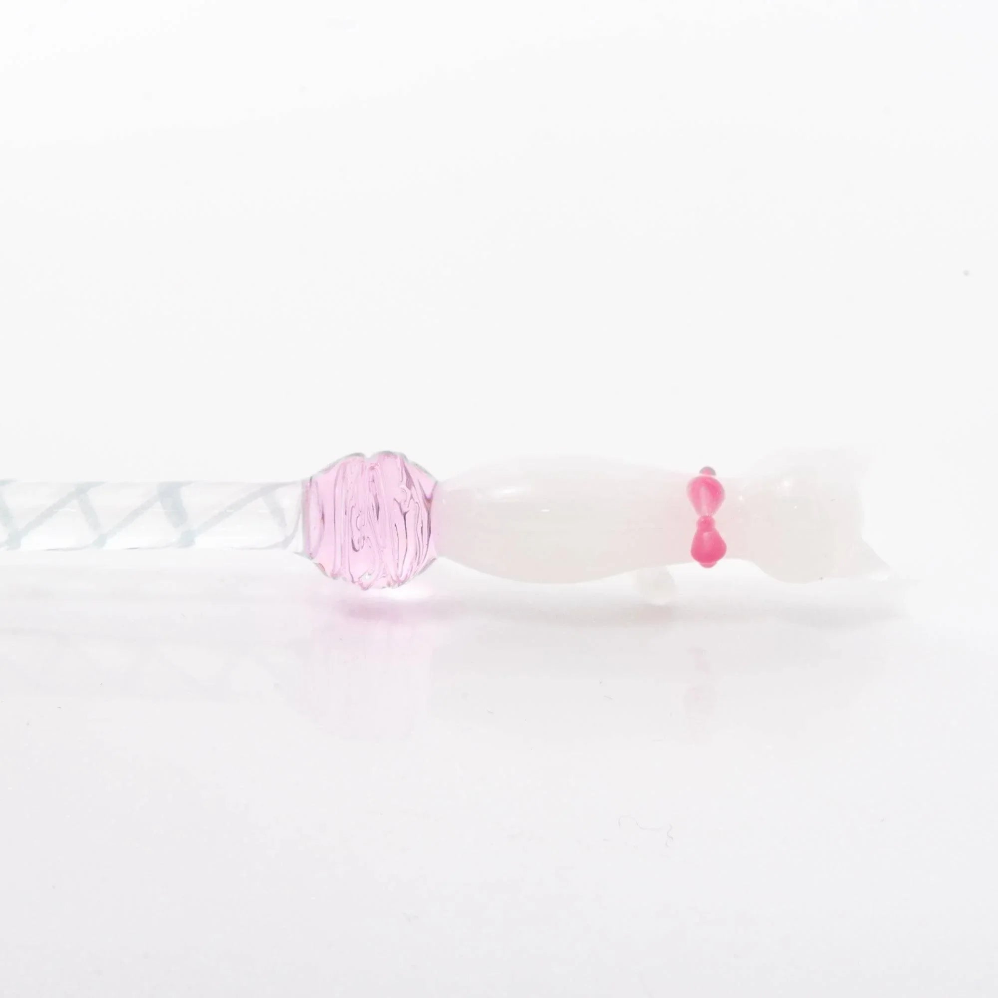 White Nyanko cat glass dip pen in hand showing clear glass barrel with pink decorative bead ornament detail