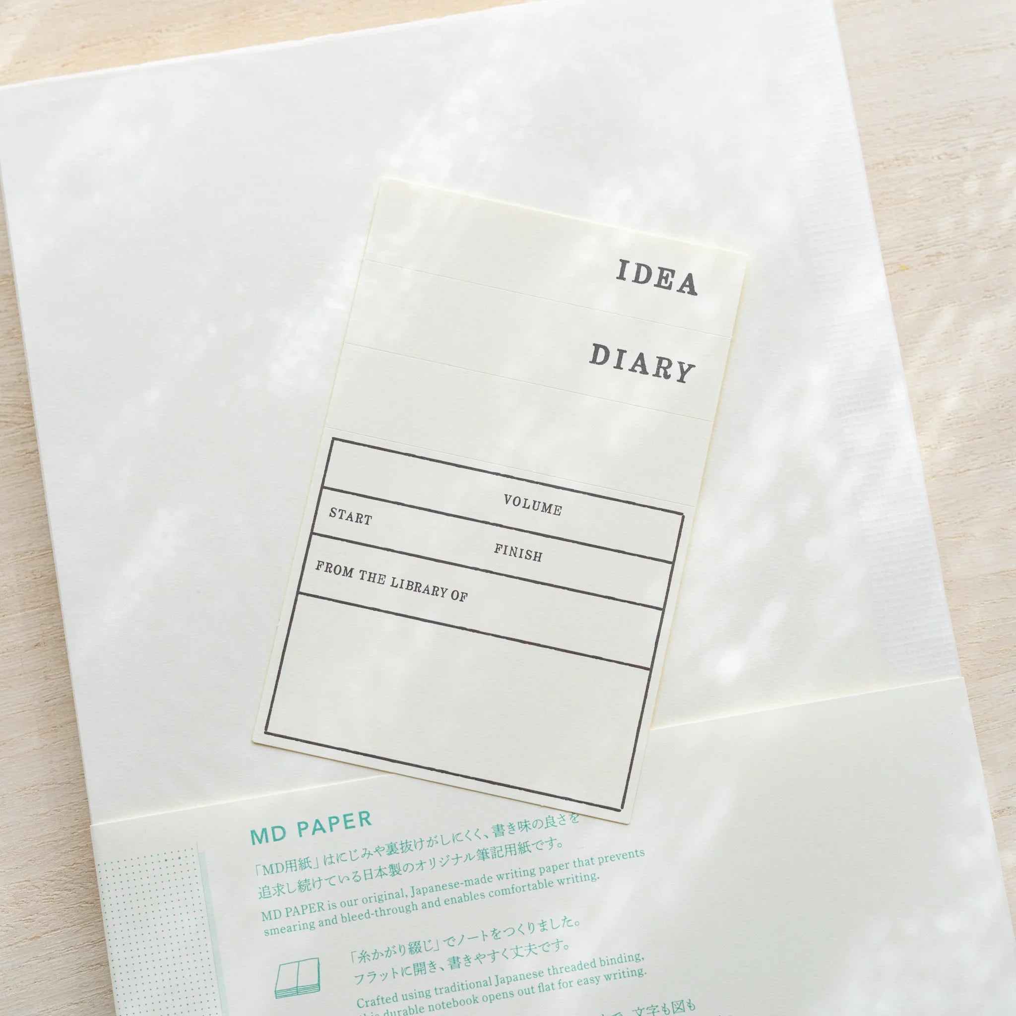 Midori MD Notebook A5 in glassine wrapping, belly band with IDEA Diary fill-in label showing Volume, Start, Finish fields