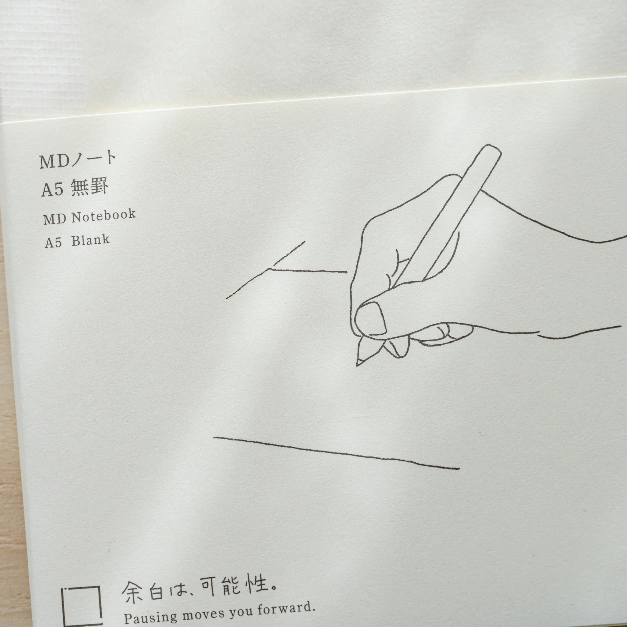 Midori MD Notebook A5 Blank belly band with black line illustration of hand writing, text MD Notebook A5 Blank