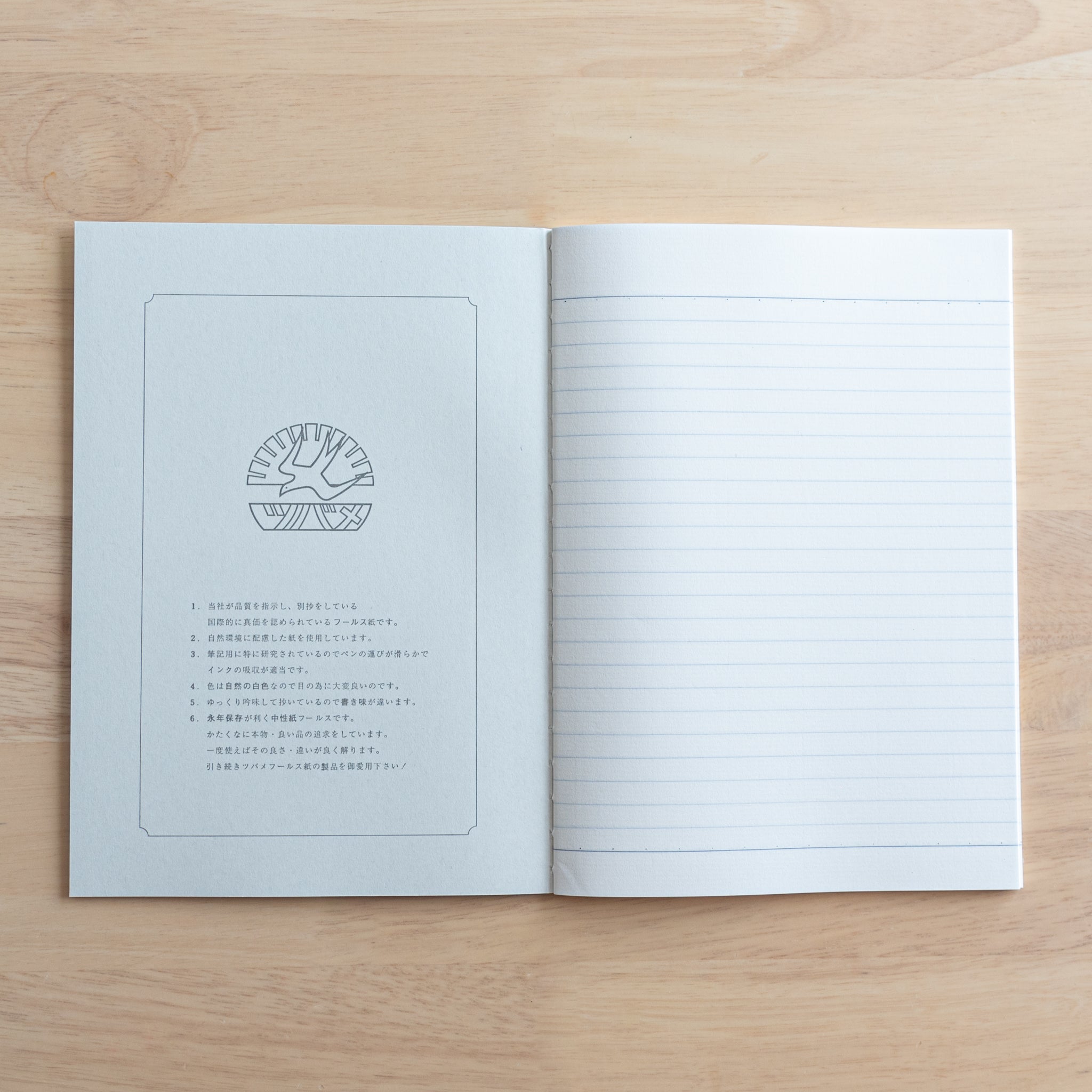 An open Tsubame Japanese notebook displaying a logo and product details on the left page and fine-quality lined paper on the right, showcasing premium Japanese stationery.  