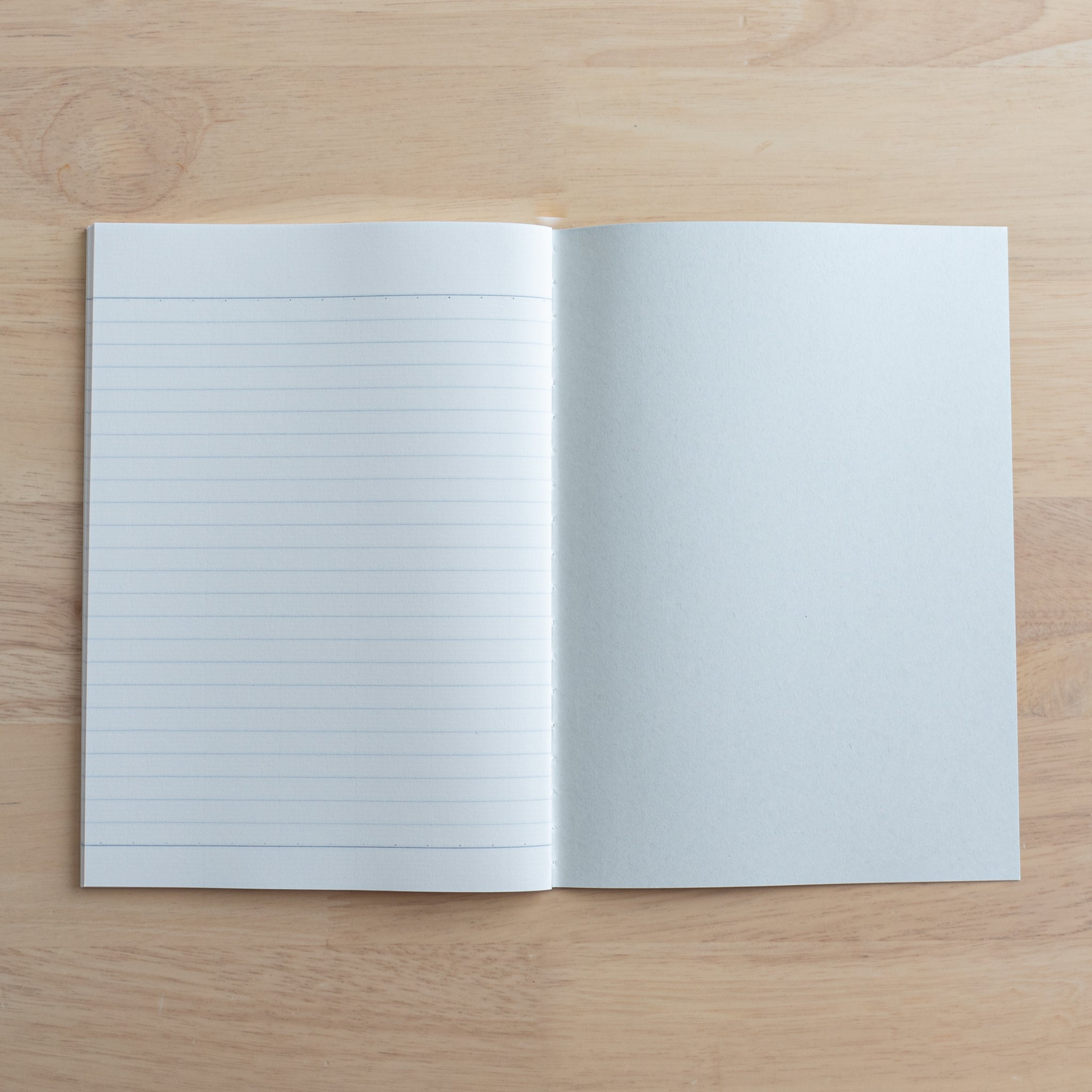 An open Tsubame Japanese notebook showing a lined page on the left and a blank inner cover on the right, crafted with high-quality Japanese stationery design.  