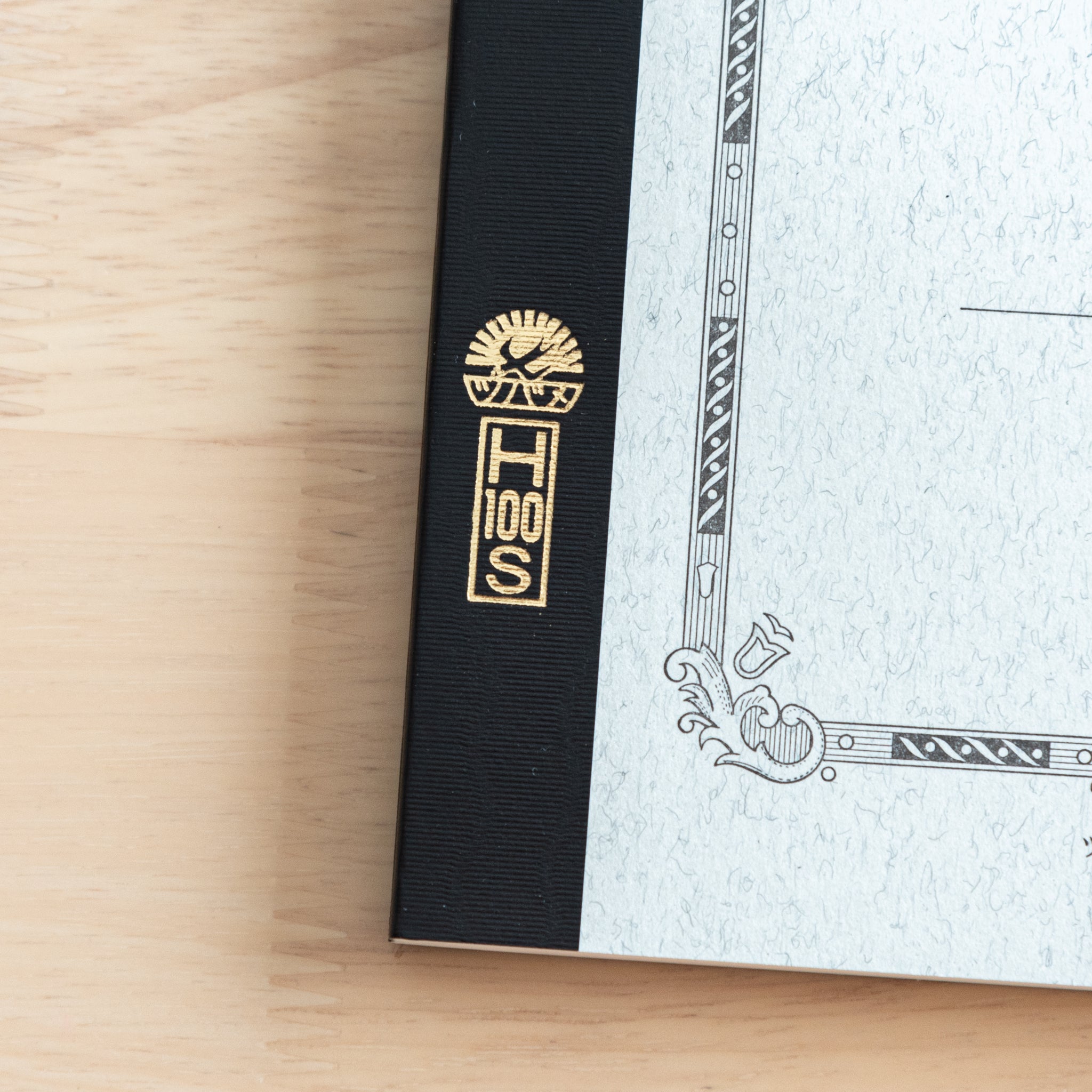 A close-up of the Tsubame Japanese notebook’s gold-stamped spine label, featuring the brand’s logo and model number, emphasizing fine Japanese stationery details.  