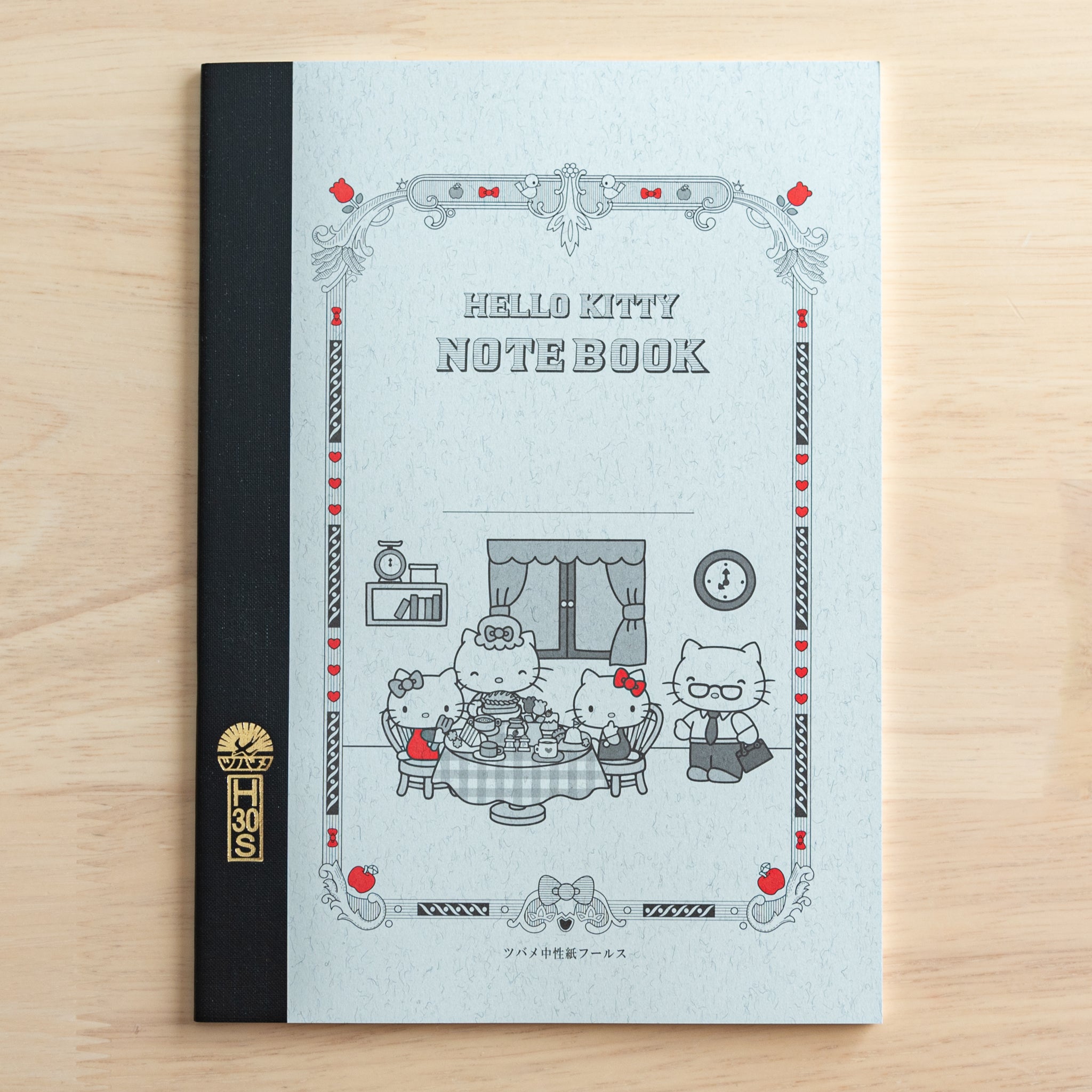 A Tsubame Japanese notebook featuring a Hello Kitty design, with an ornate cover, black spine, and red accents, blending classic Japanese stationery with a cute aesthetic.  