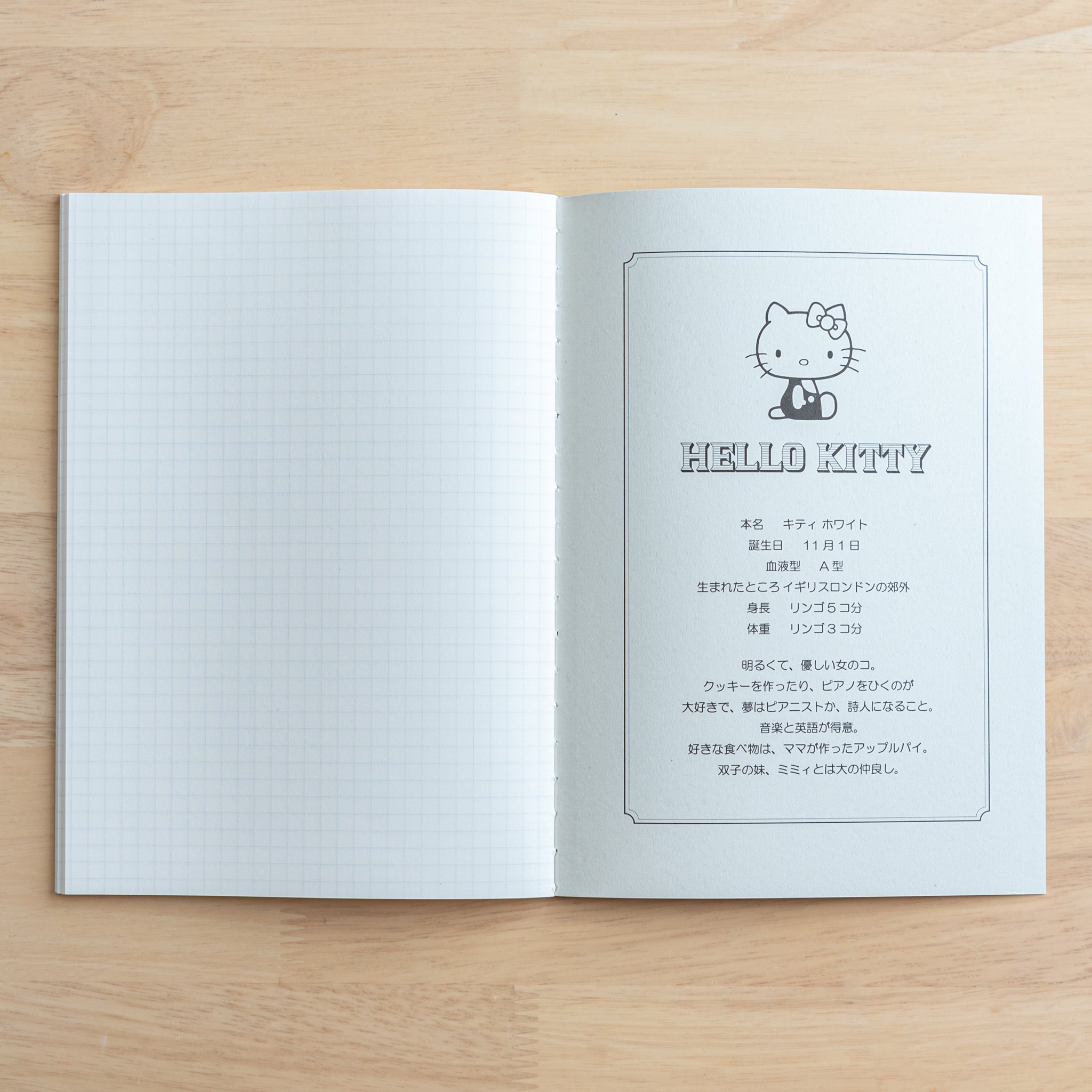 An open Tsubame Japanese notebook with a Hello Kitty design, featuring a biography page on the right and fine-quality grid paper on the left, blending functionality with charm.  