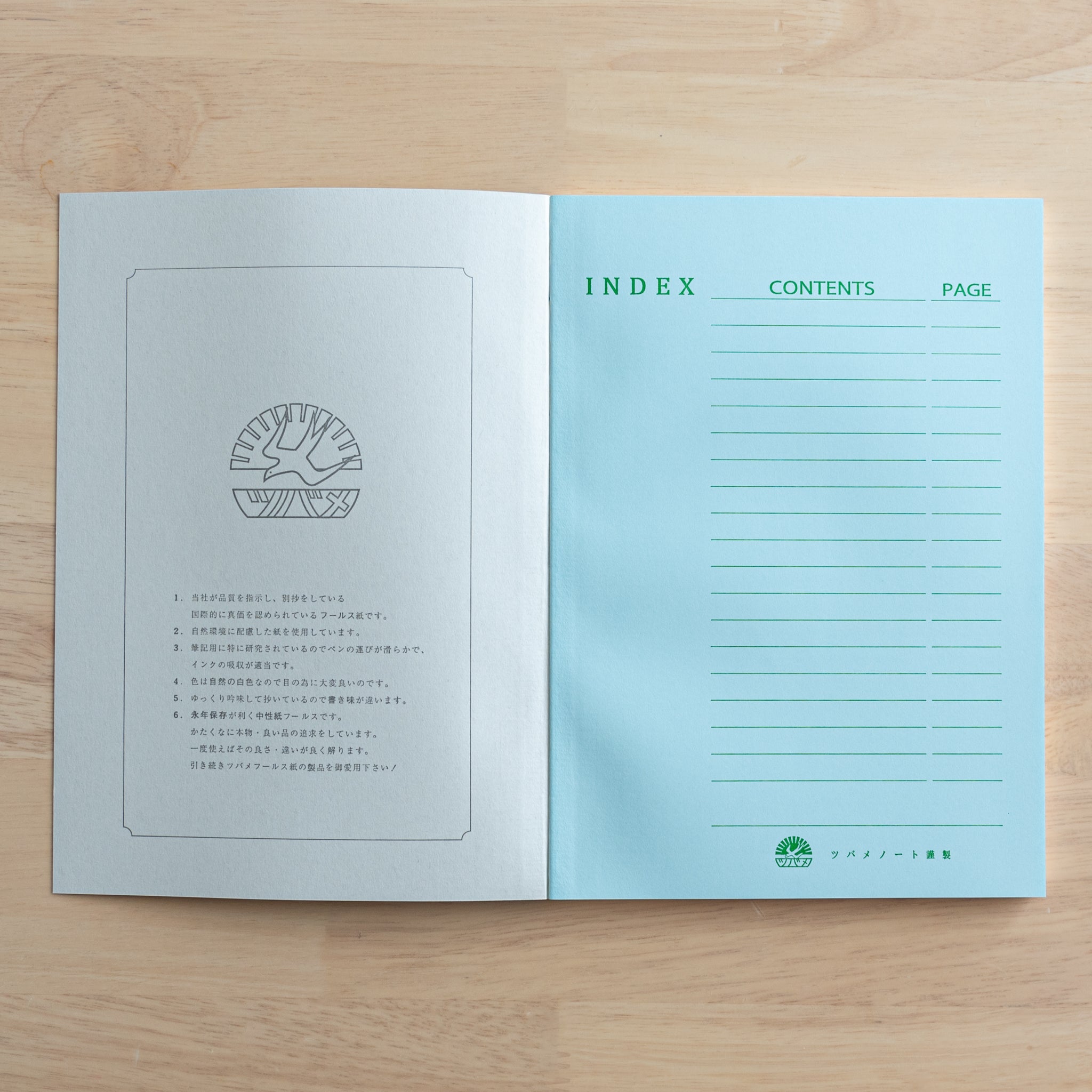 An open Tsubame Japanese notebook showing a blue inner cover on the left and a lined page on the right, crafted with high-quality paper and classic Japanese stationery design.  