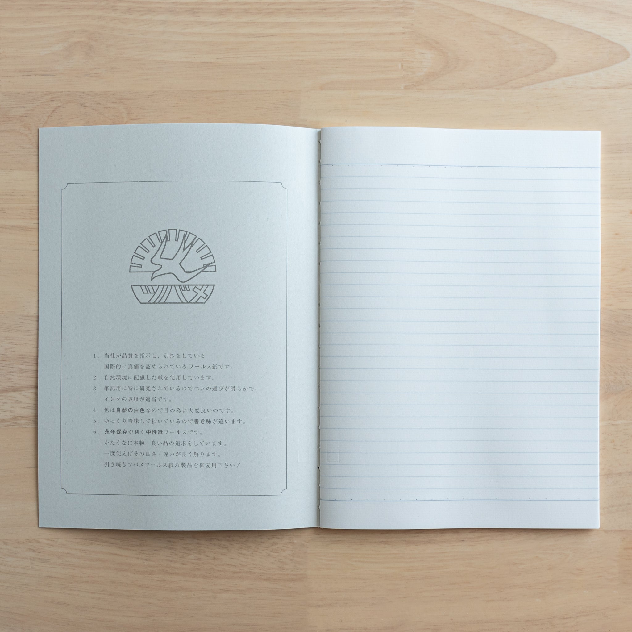 An open Tsubame Japanese notebook displaying a logo and product details on the left page and fine-quality lined paper on the right, showcasing premium Japanese stationery.  