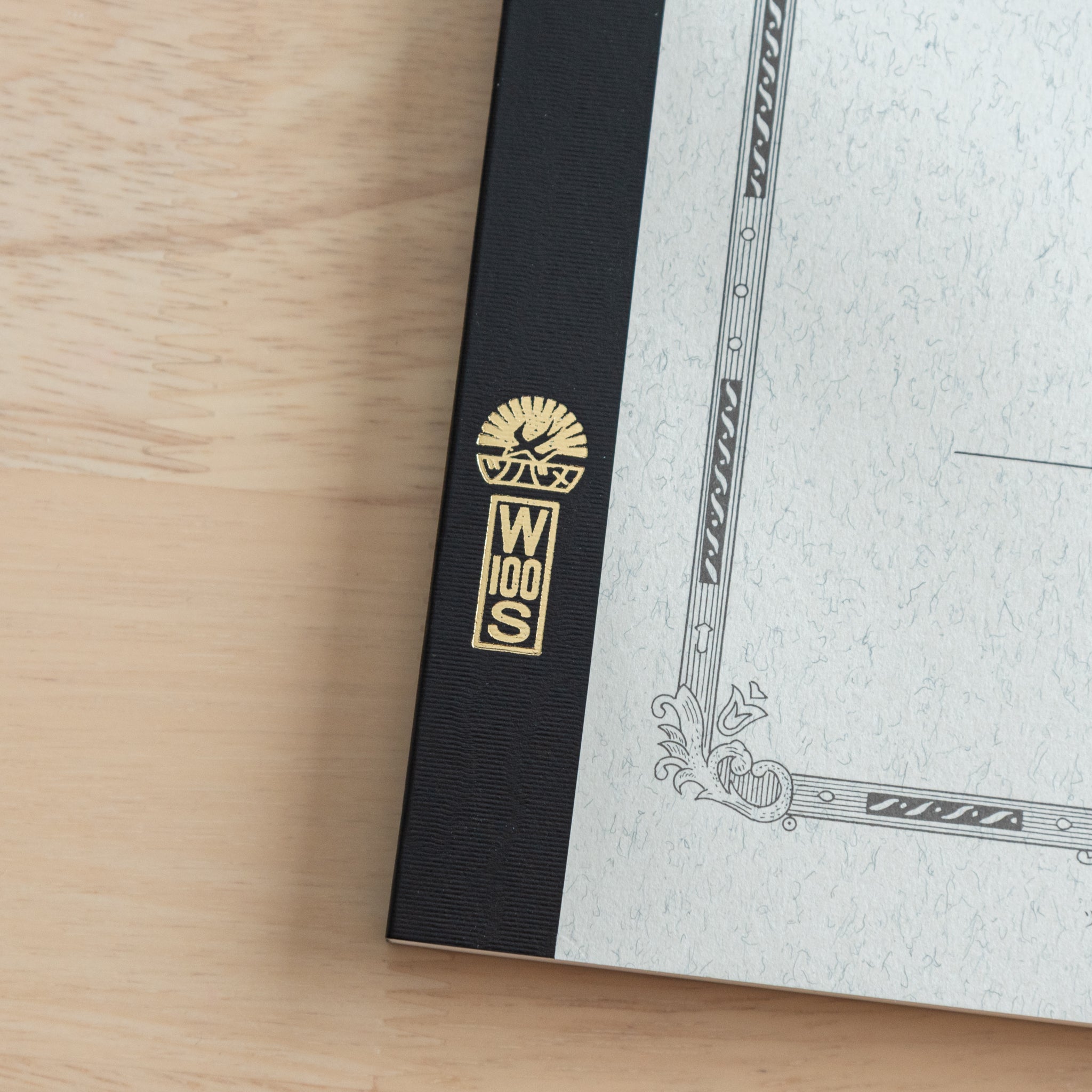 A close-up of the Tsubame Japanese notebook’s gold-stamped spine label, featuring the brand’s logo and model number, emphasizing fine Japanese stationery details.  