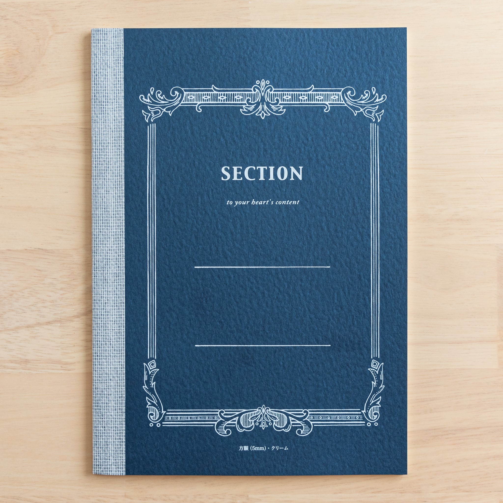 A Tsubame Japanese notebook with a navy blue cover labeled "Section," featuring an ornate vintage-style design. A refined piece of Japanese stationery.