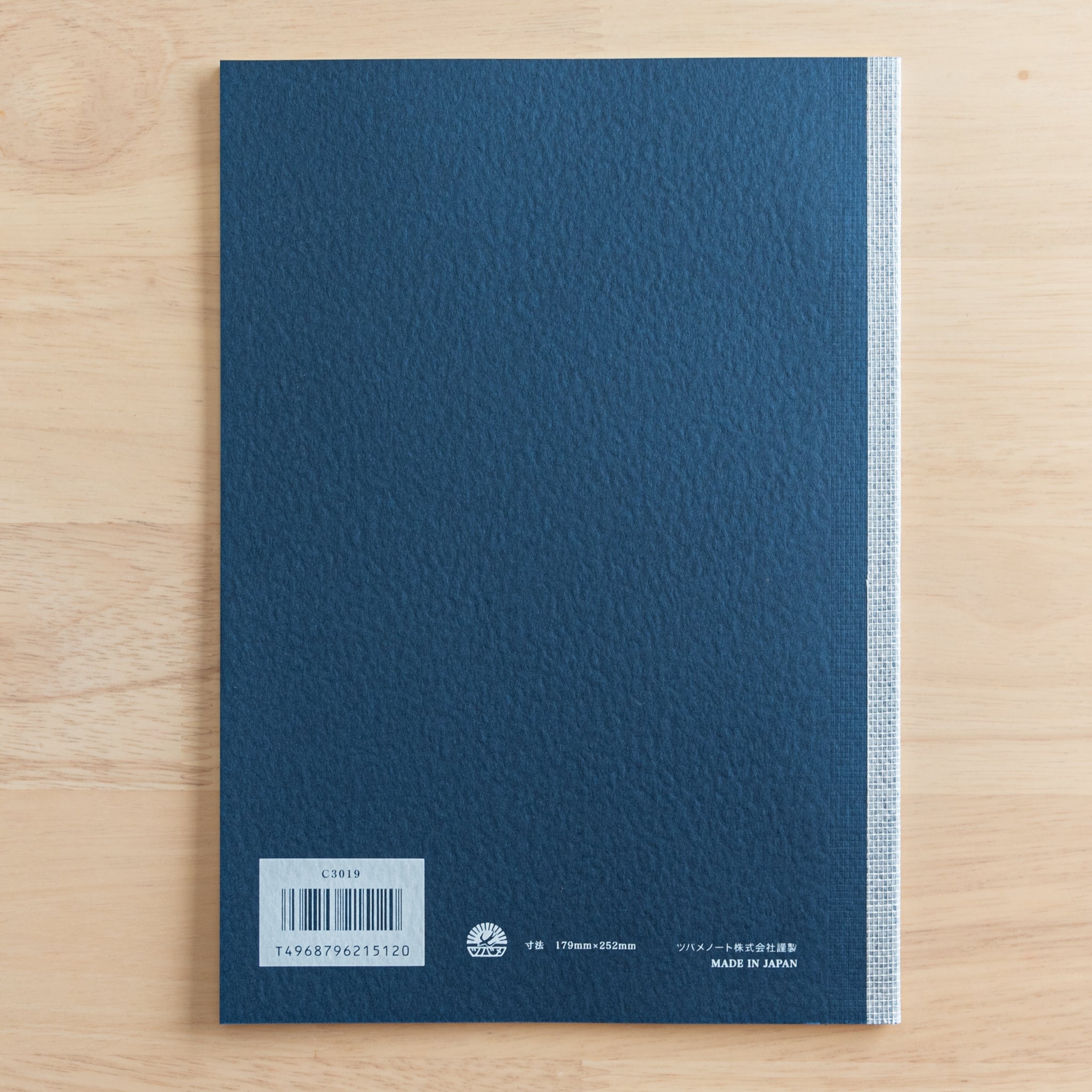 The back cover of a Tsubame Japanese notebook with a navy blue textured finish, barcode, and "Made in Japan" label. A refined piece of Japanese stationery.