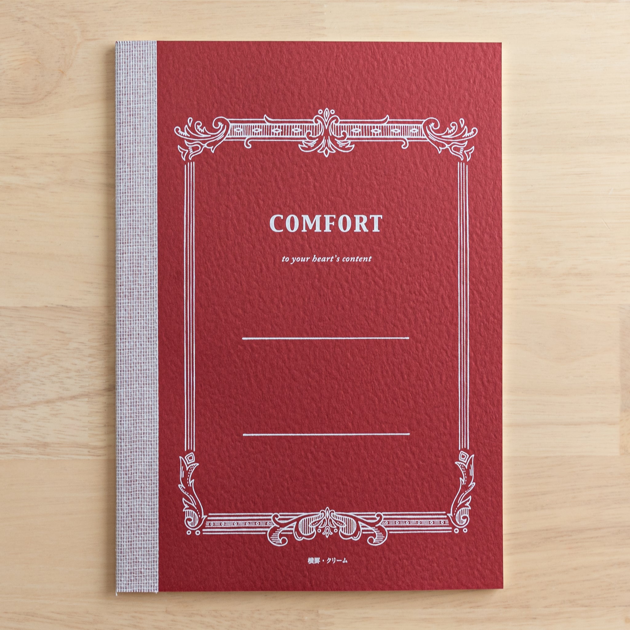 A Tsubame Japanese notebook with a red cover labeled "Comfort," featuring an elegant vintage-style design. A refined piece of Japanese stationery.