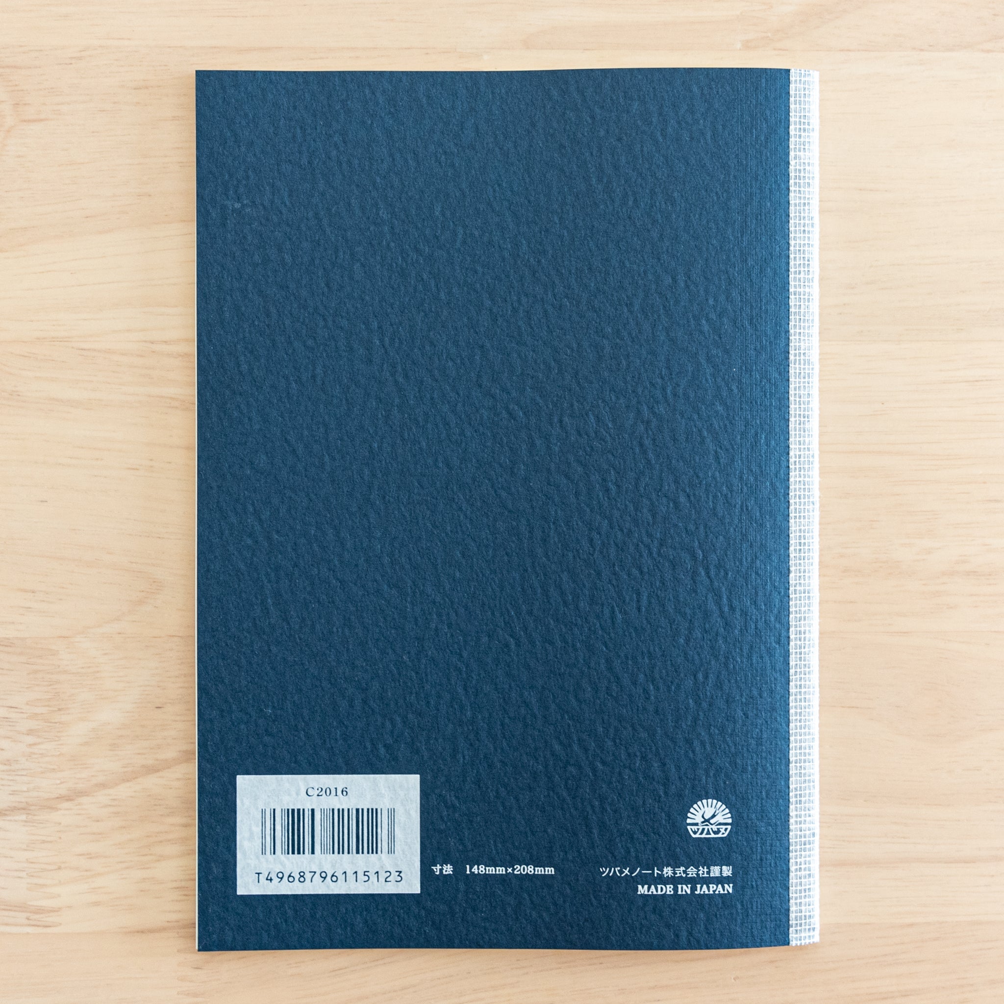 The back cover of a Tsubame Japanese notebook with a navy blue textured finish, barcode, and "Made in Japan" label. A refined piece of Japanese stationery.