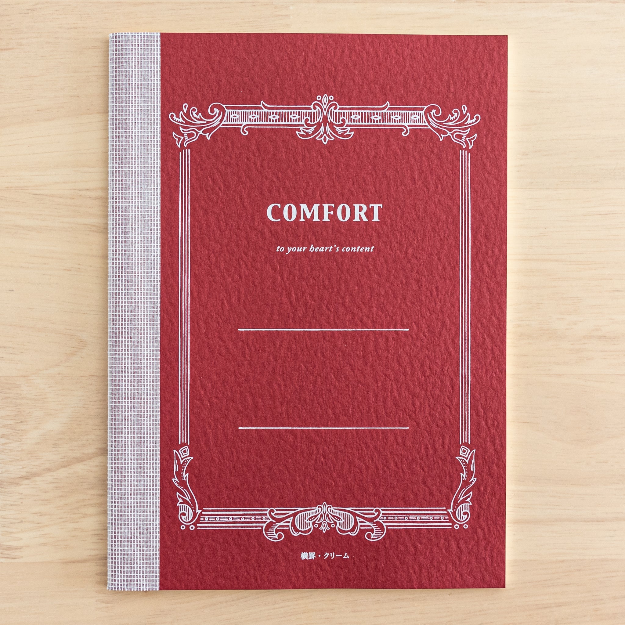 A Tsubame Japanese notebook with a red cover labeled "Comfort," featuring an elegant vintage-style design. A refined piece of Japanese stationery.