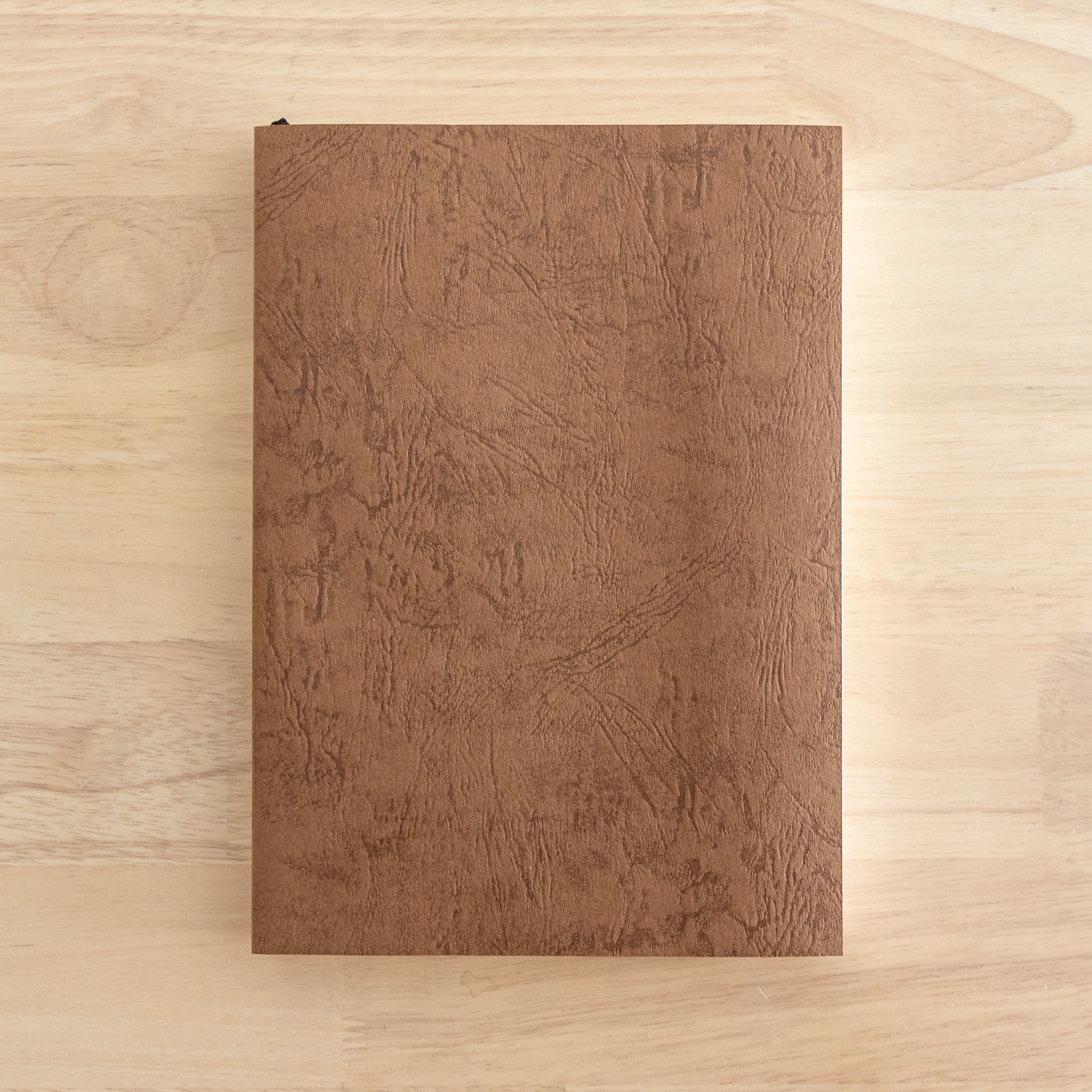 Tsubame Japanese notebook, Premium Thick model. A high-quality Japanese stationery item with a brown textured cover, placed on a wooden surface.  