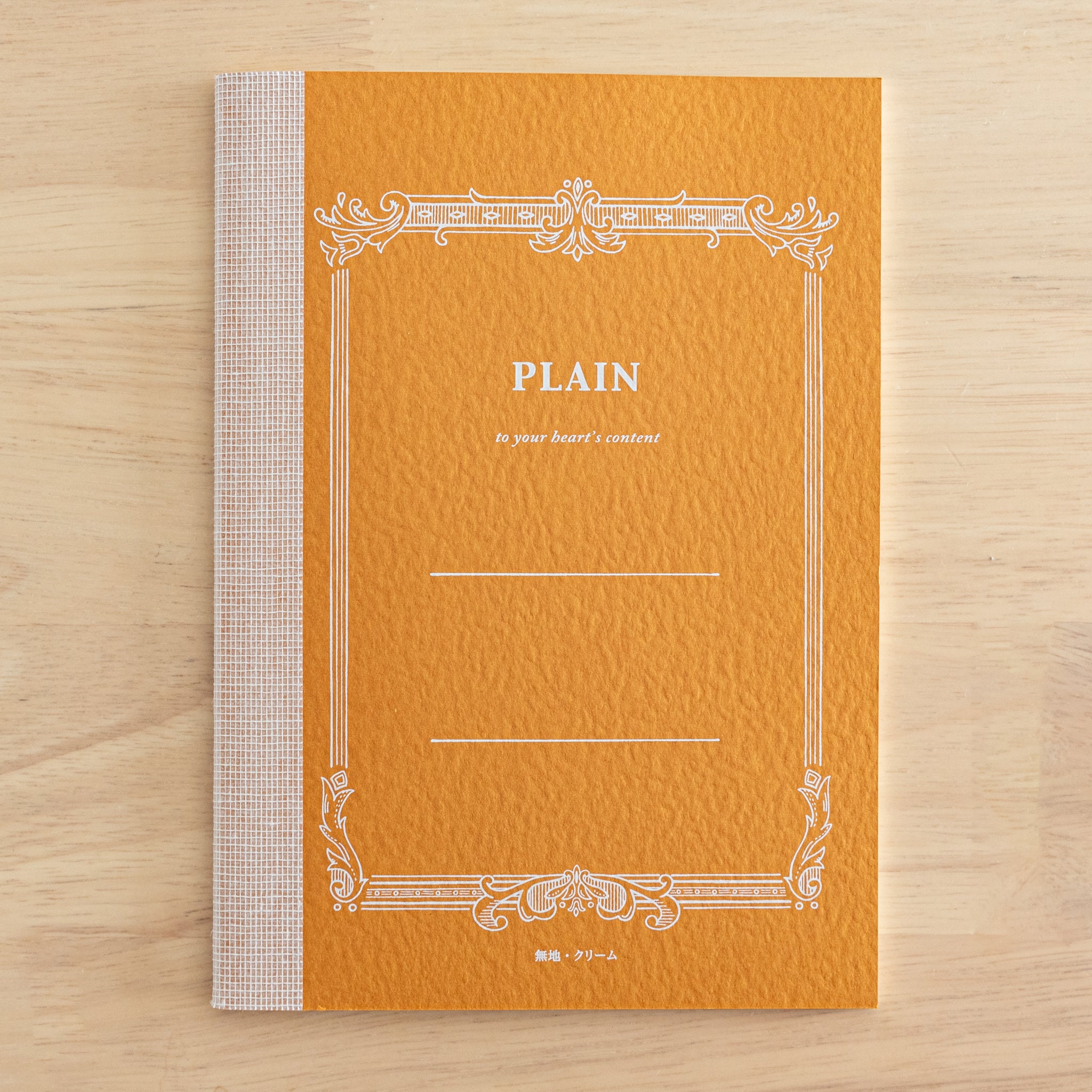 A single orange Tsubame Japanese notebook labeled "Plain" with an ornate border. A beautiful example of traditional Japanese stationery.