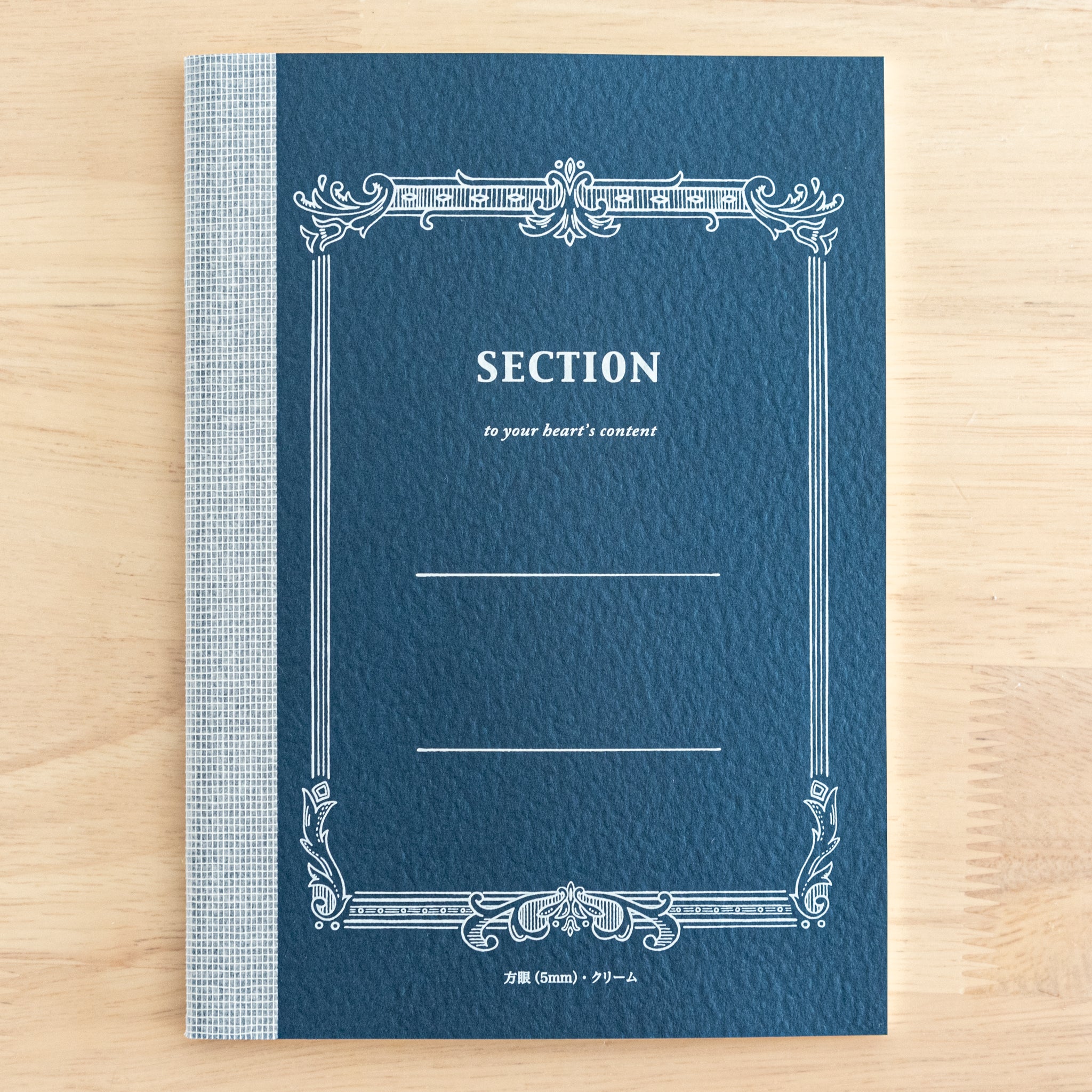 A Tsubame Japanese notebook with a navy blue cover labeled "Section," featuring an ornate vintage-style design. A refined piece of Japanese stationery.