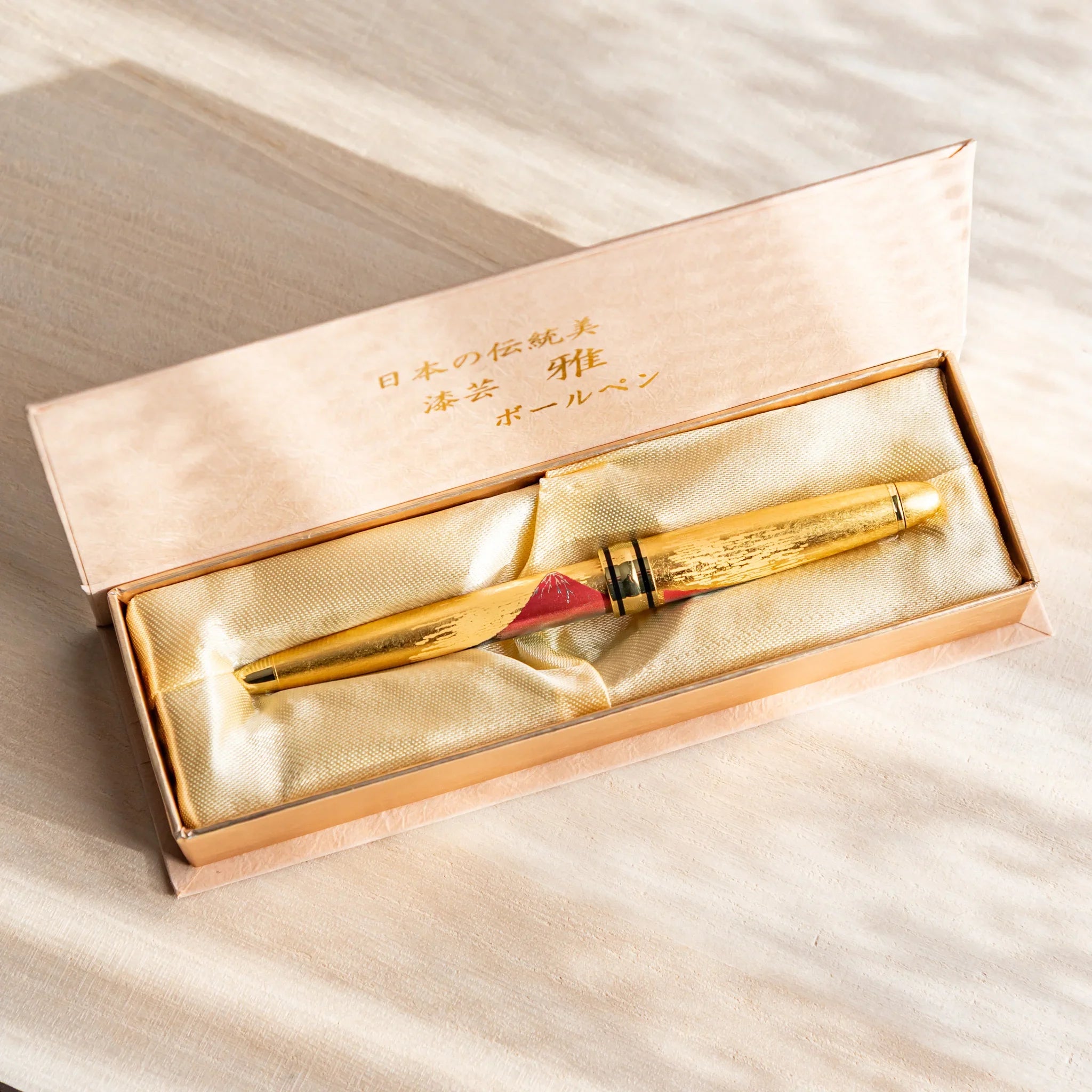 Gold Leaf Mt. Fuji Japanese Ballpoint Pen in a satin-lined gold gift box, featuring red Fuji artwork and a gold body.