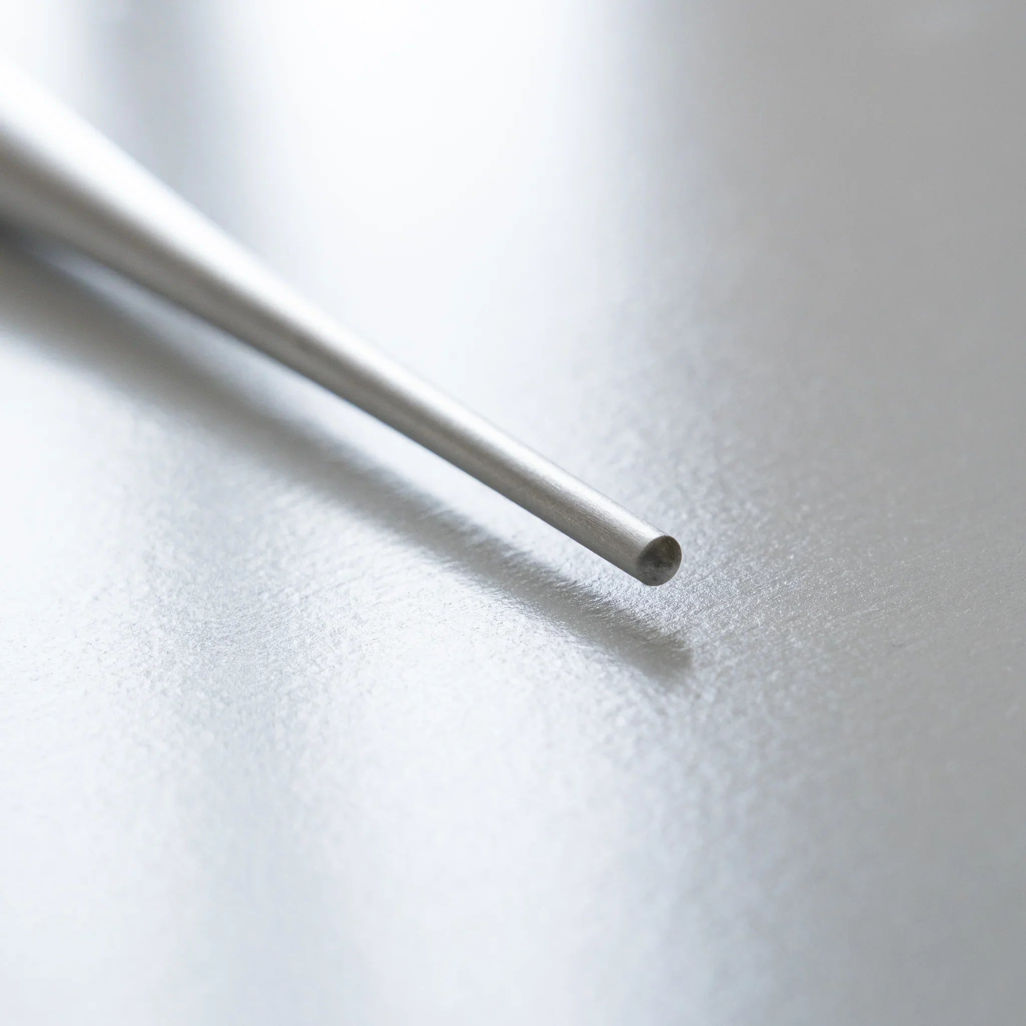 Close-up of polished silver tapered ballpoint pen tip showing fine sharp pointed writing end clearly