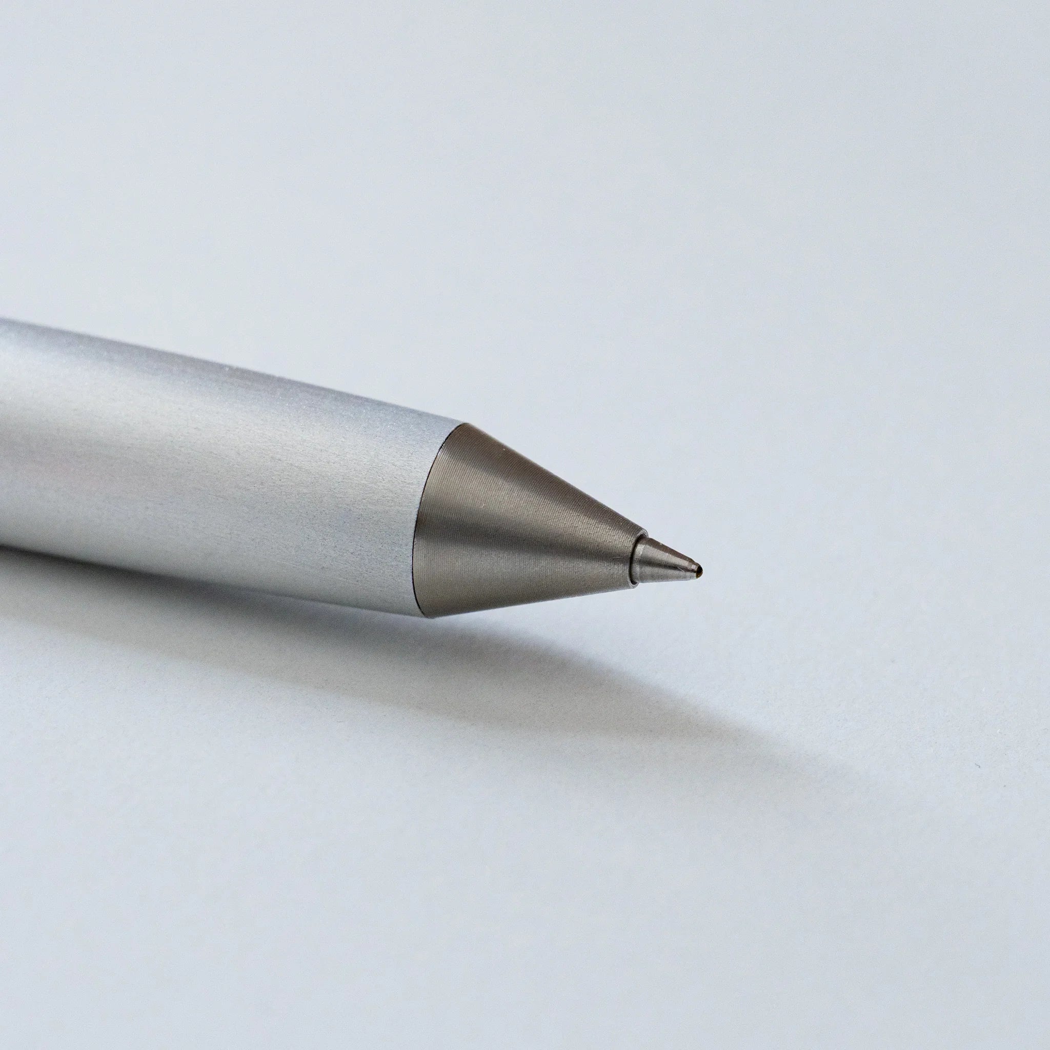 Detailed close-up angled view of brushed duralumin ballpoint pen showing tapered body form and sharp point