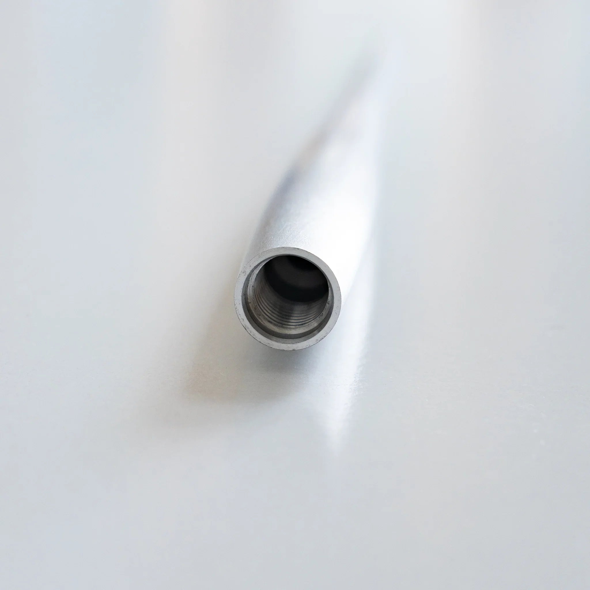 Macro photograph of threaded ball pen nib opening showing internal mechanism structure and hollow center opening