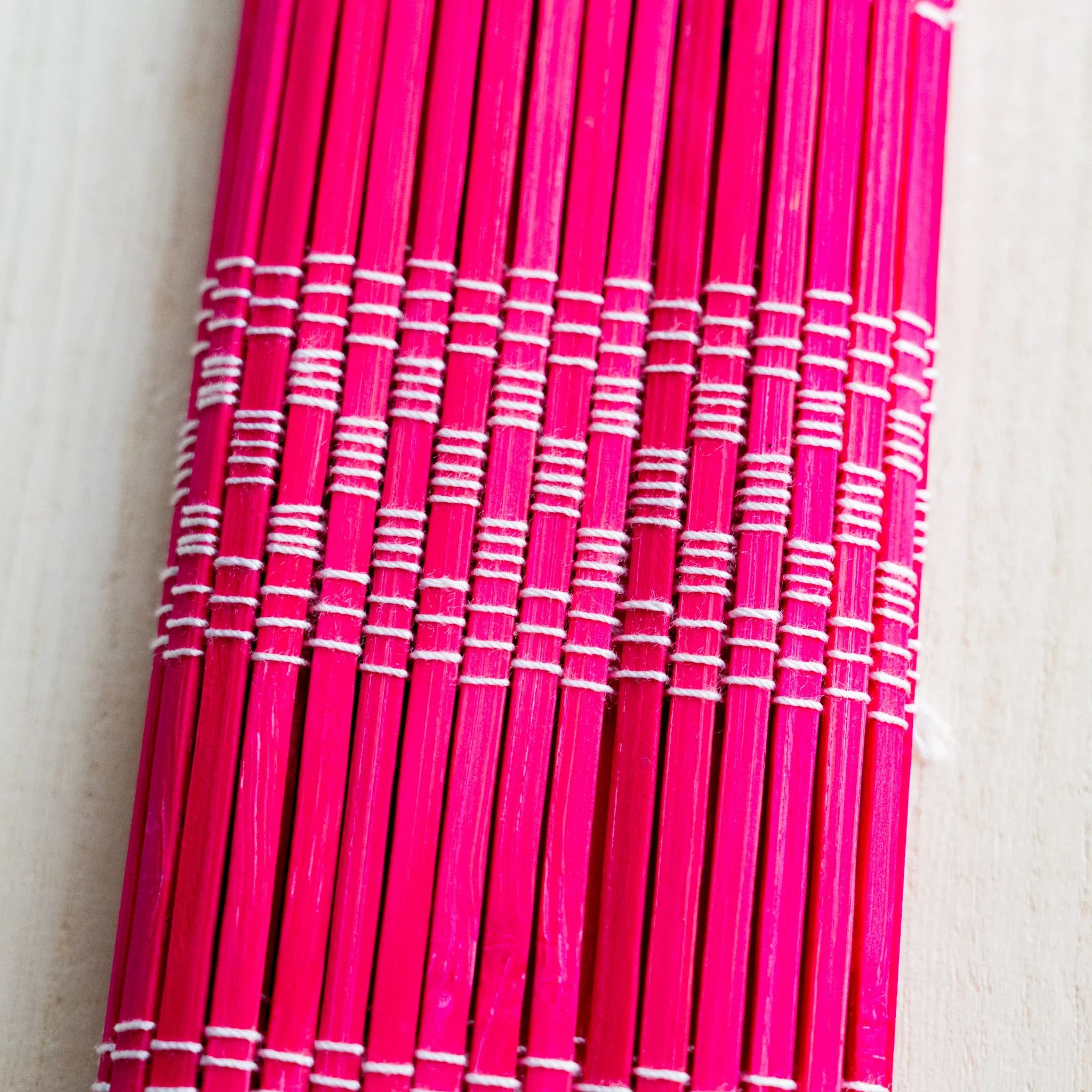 Akashiya fudemaki brush wrap in red, partly rolled showing interior weave