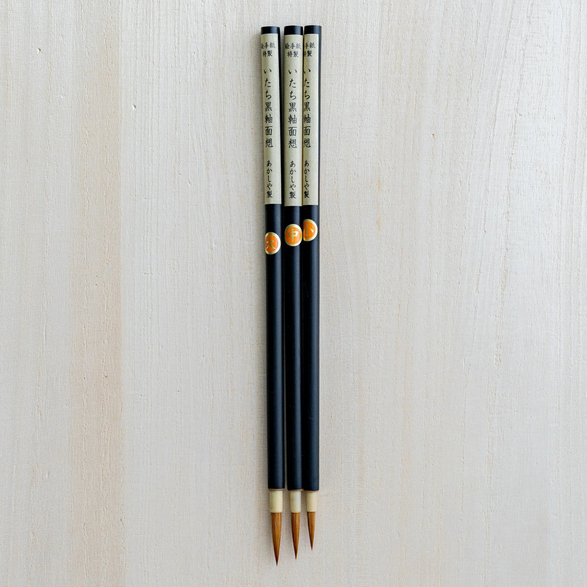 Akashiya Menso brushes laid flat showing the full handle length and bristle tip